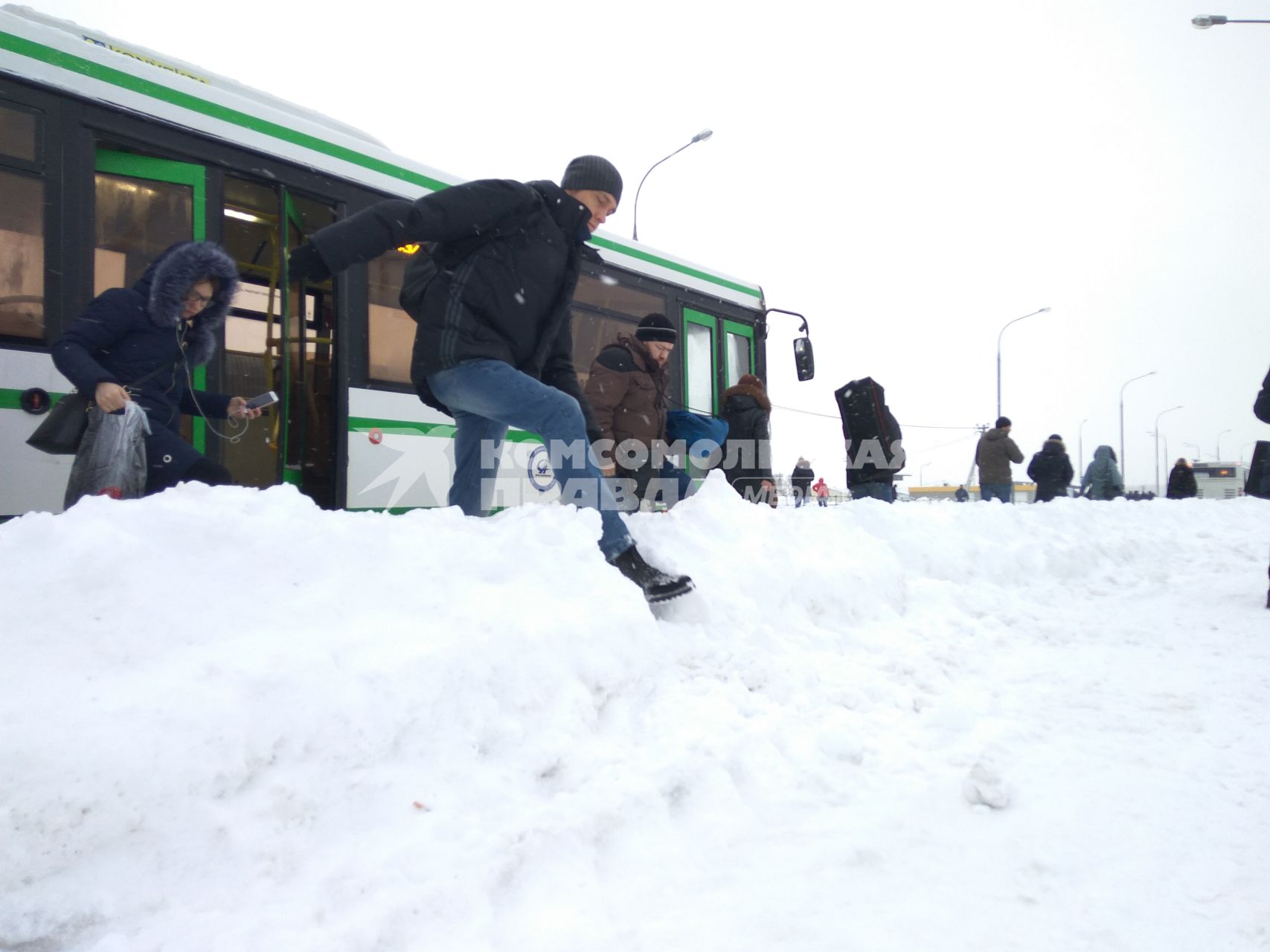 Москва.   Пассажиры выходят из автобуса на остановке у метро `Саларьево`.