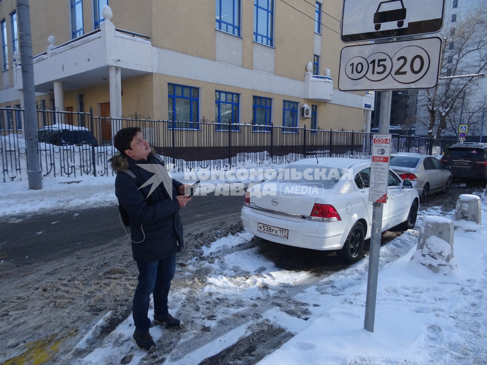 Москва.  Корреспондент `Комсомольской правды` Павел Клоков   у знака платной парковки.