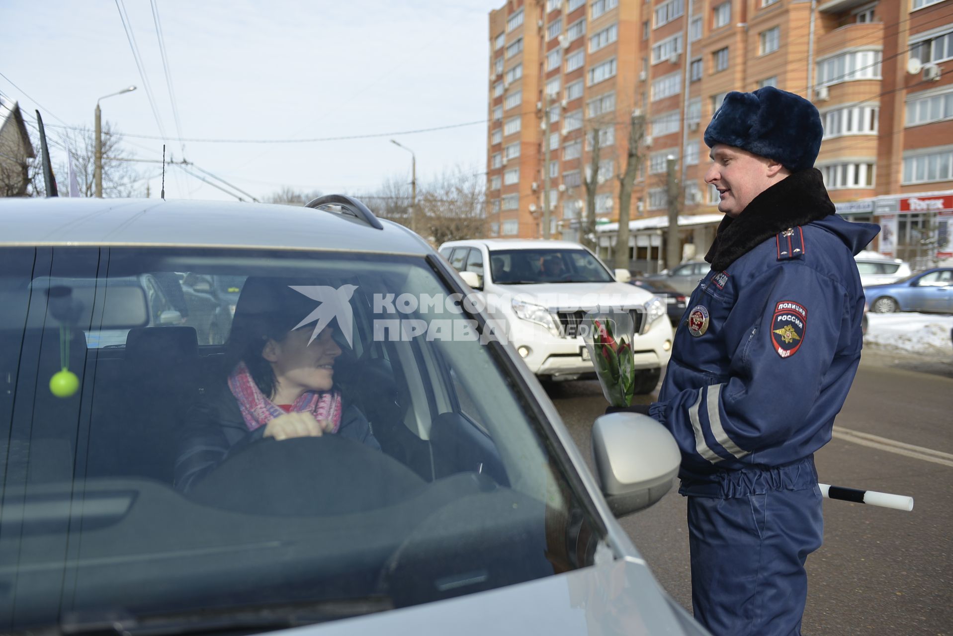 Тула. Сотрудник ДПС  поздравляет женщину-водителя в преддверии празднования Международного женского дня.