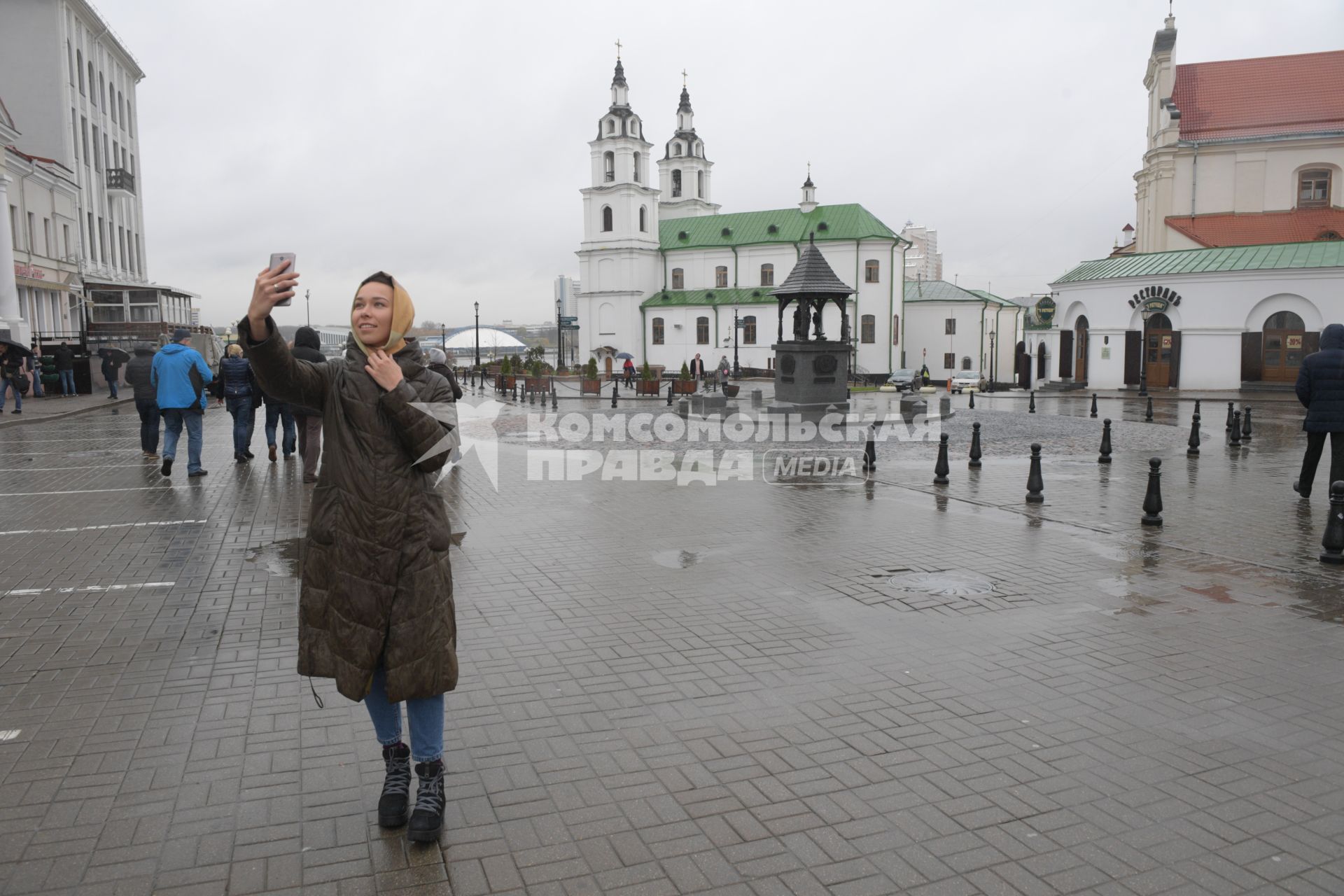 Беларусь, Минск.  Девушка фотографируется  на площади Свободы  у ратуши.