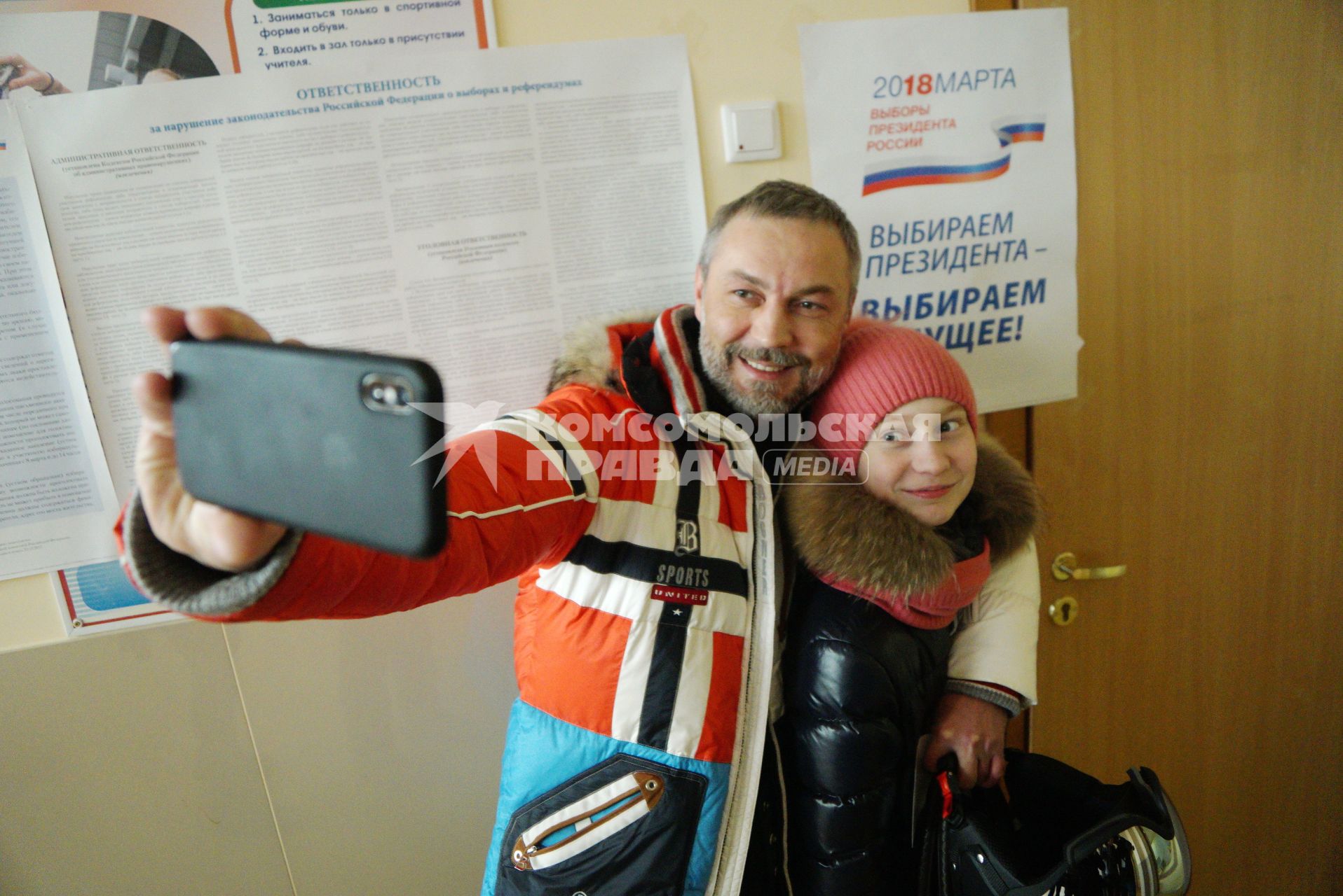 Екатеринбург. Мужчина с дочерью делают селфиа избирательном участке во время выборов президента России в 2018г