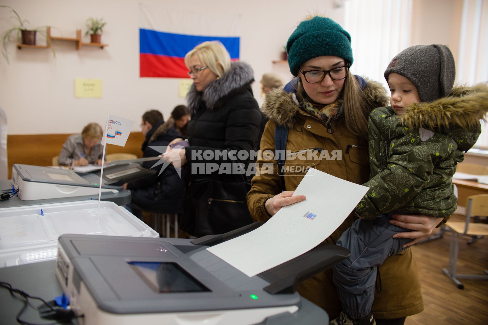 Челябинск. Девушка с ребенком во время голосования на выборах президента РФ на избирательном участке #805.