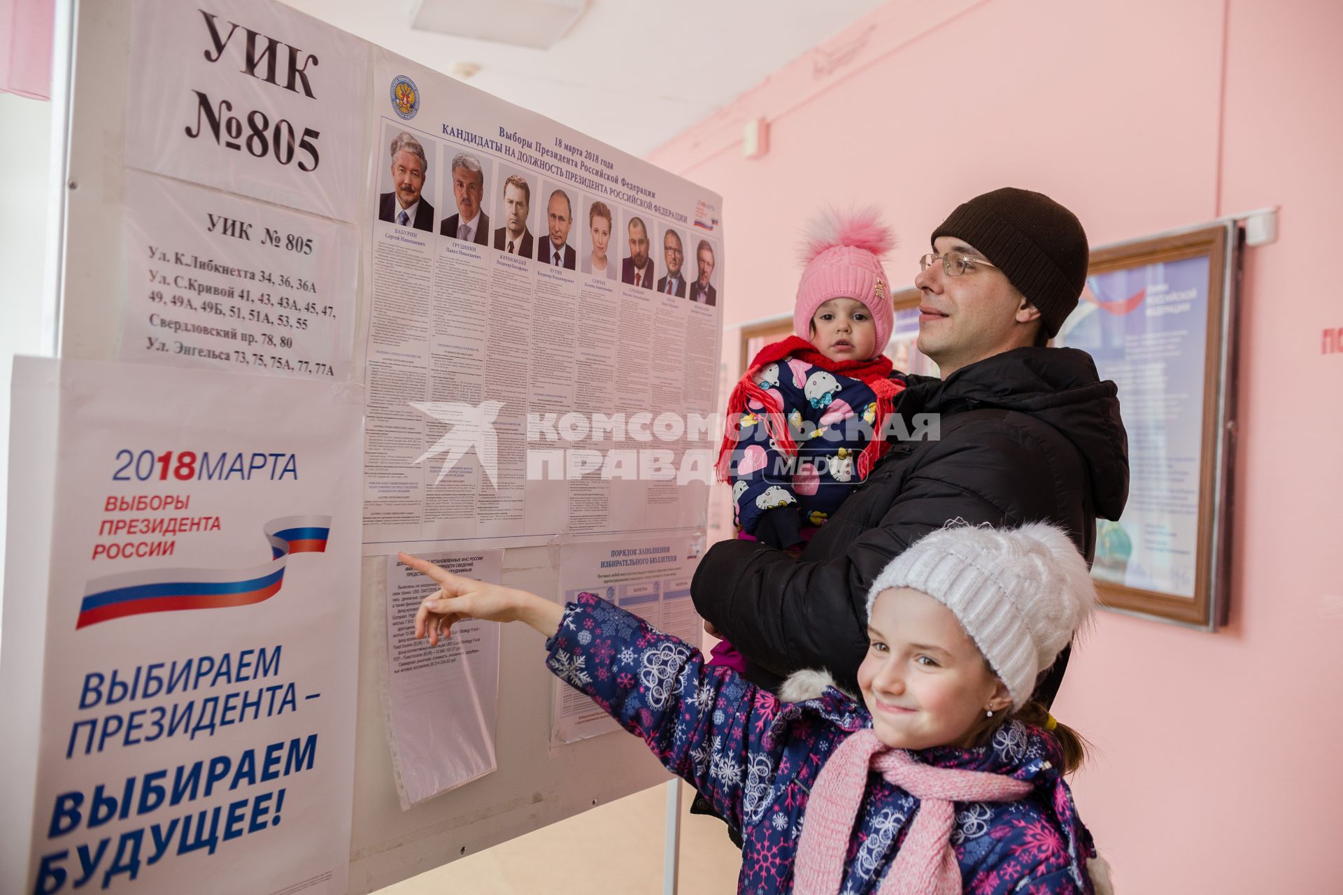 Челябинск. Мужчина с детьми у стенда с кандидатами на должность президента РФ на избирательном участке #805.