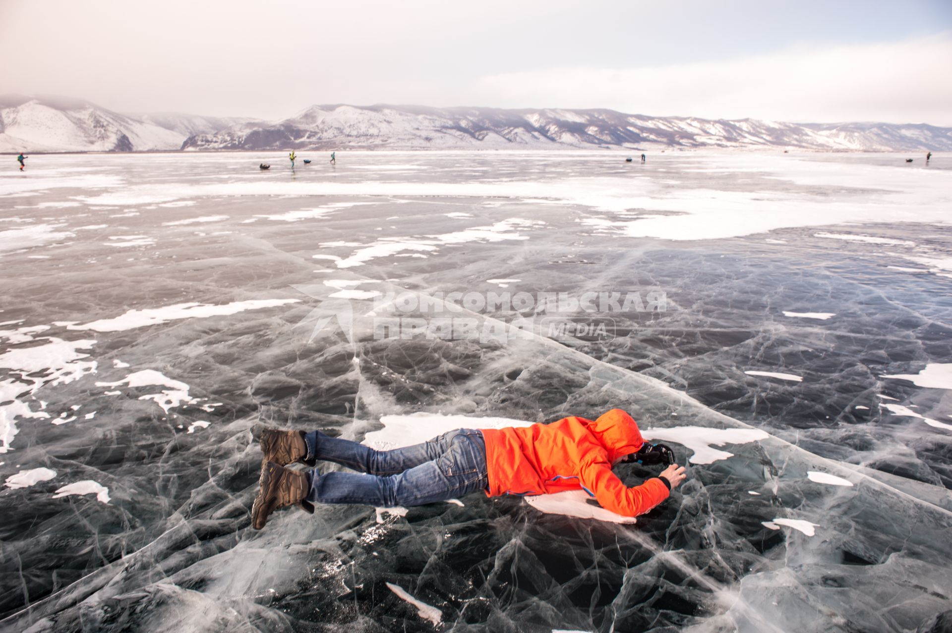 Иркутская область, озеро Байкал.  Туристы лежат на льду озера Байкал.