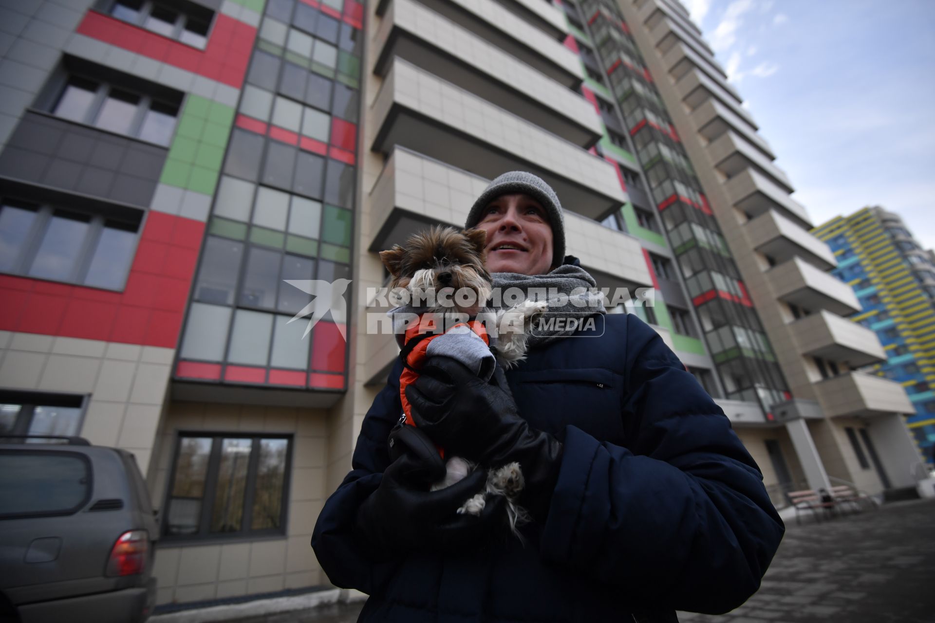 Москва. Мужчина с собакой у нового  дома ,  построенного  в рамках программы реновации на бульваре Рокоссовского.