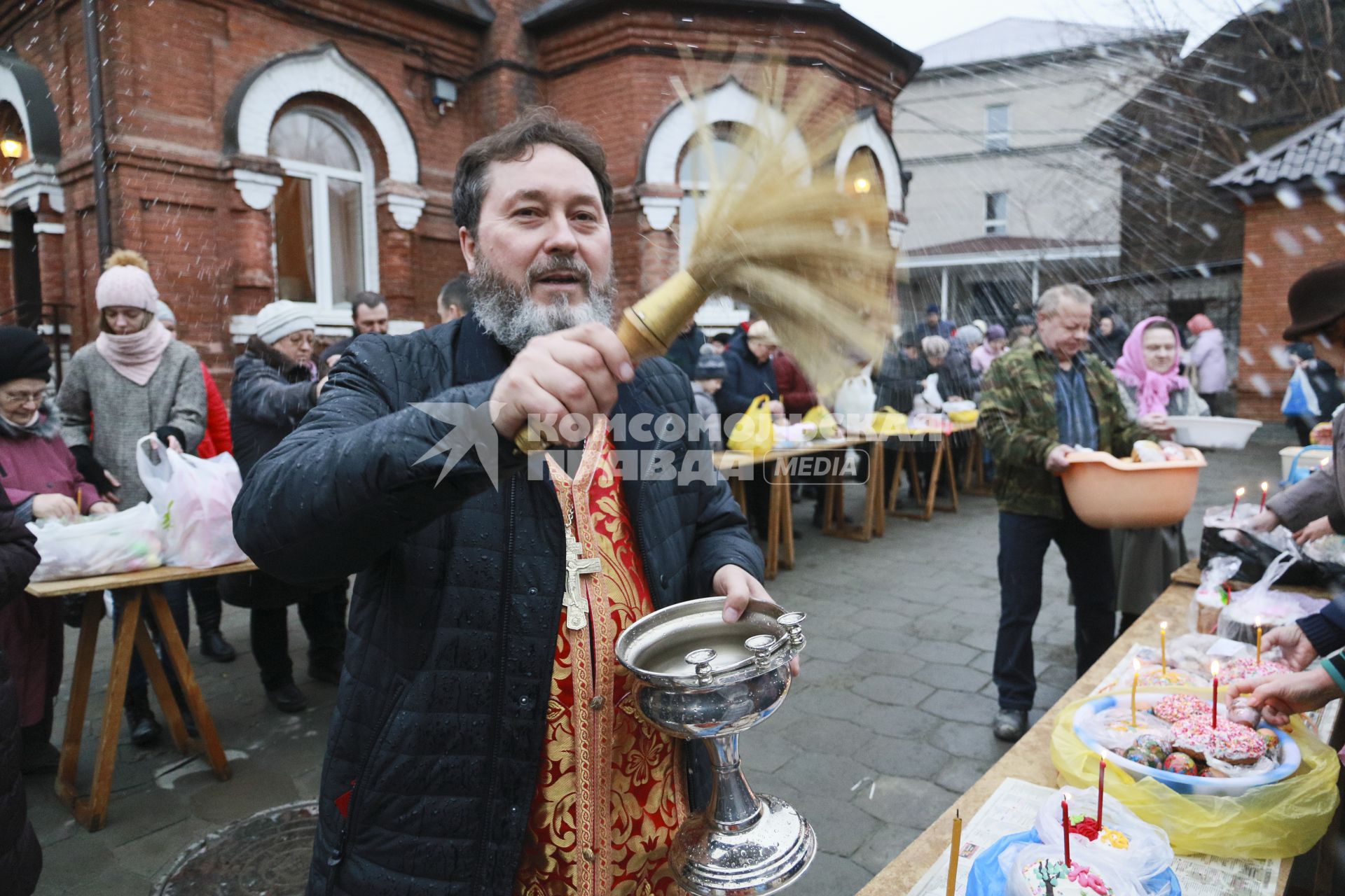 Барнаул. Священнослужитель освящает пасхальные куличи и яйца.