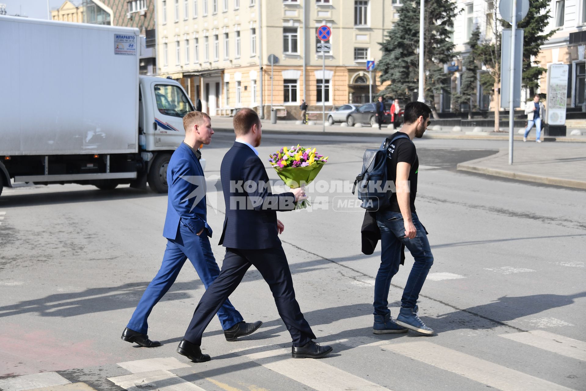 Москва. Мужчина с букетом цветов переходит улицу.