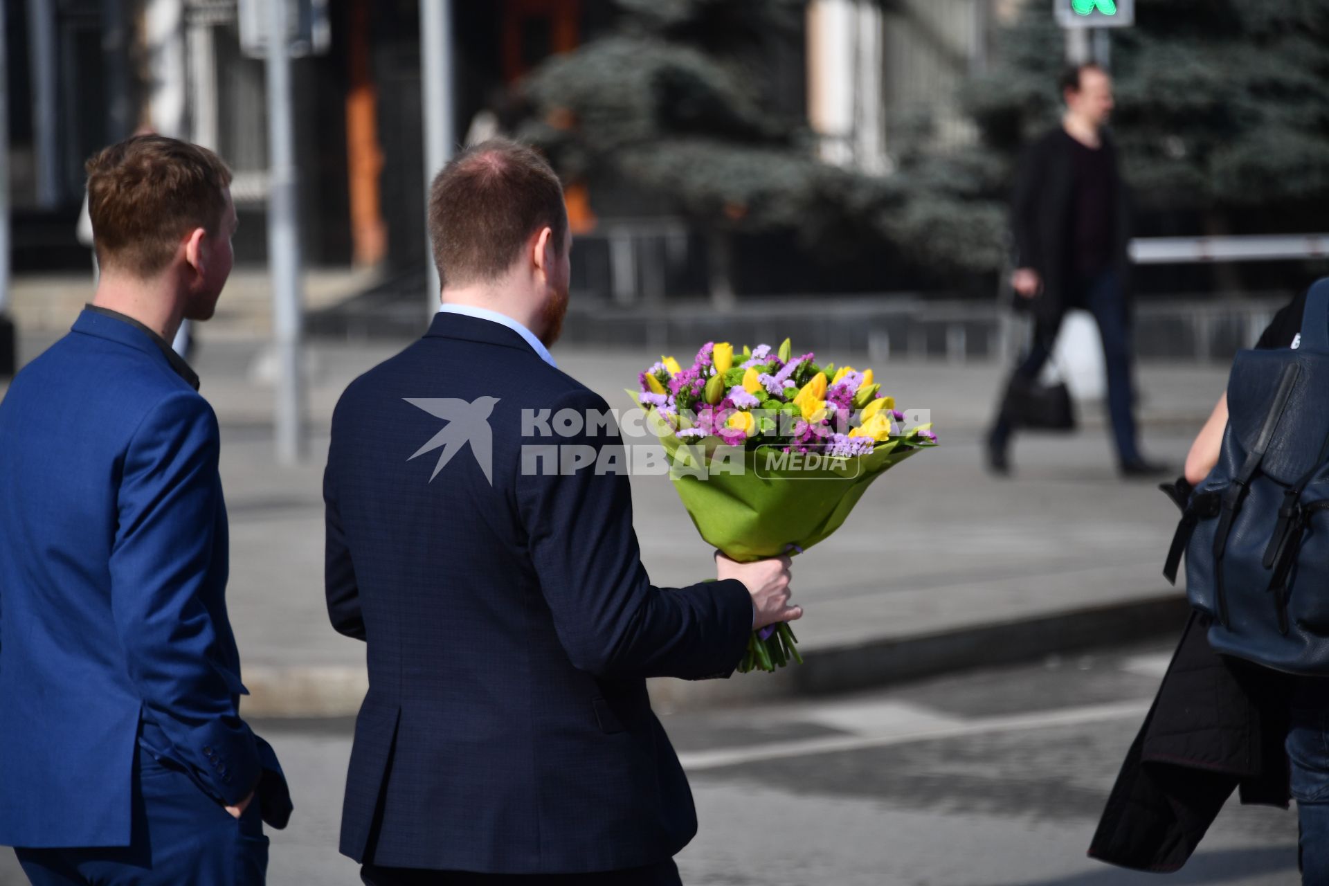 Москва. Мужчина с букетом цветов переходит улицу.