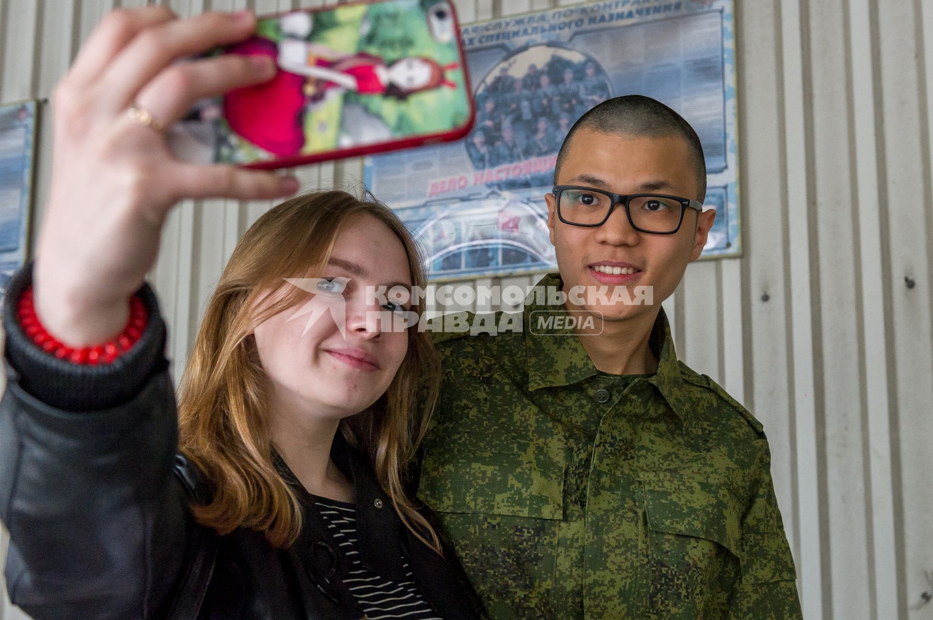 Санкт-Петербург. Девушка и молодой человек делают селфи на городском сборном пункте перед отправкой призывников на место службы.