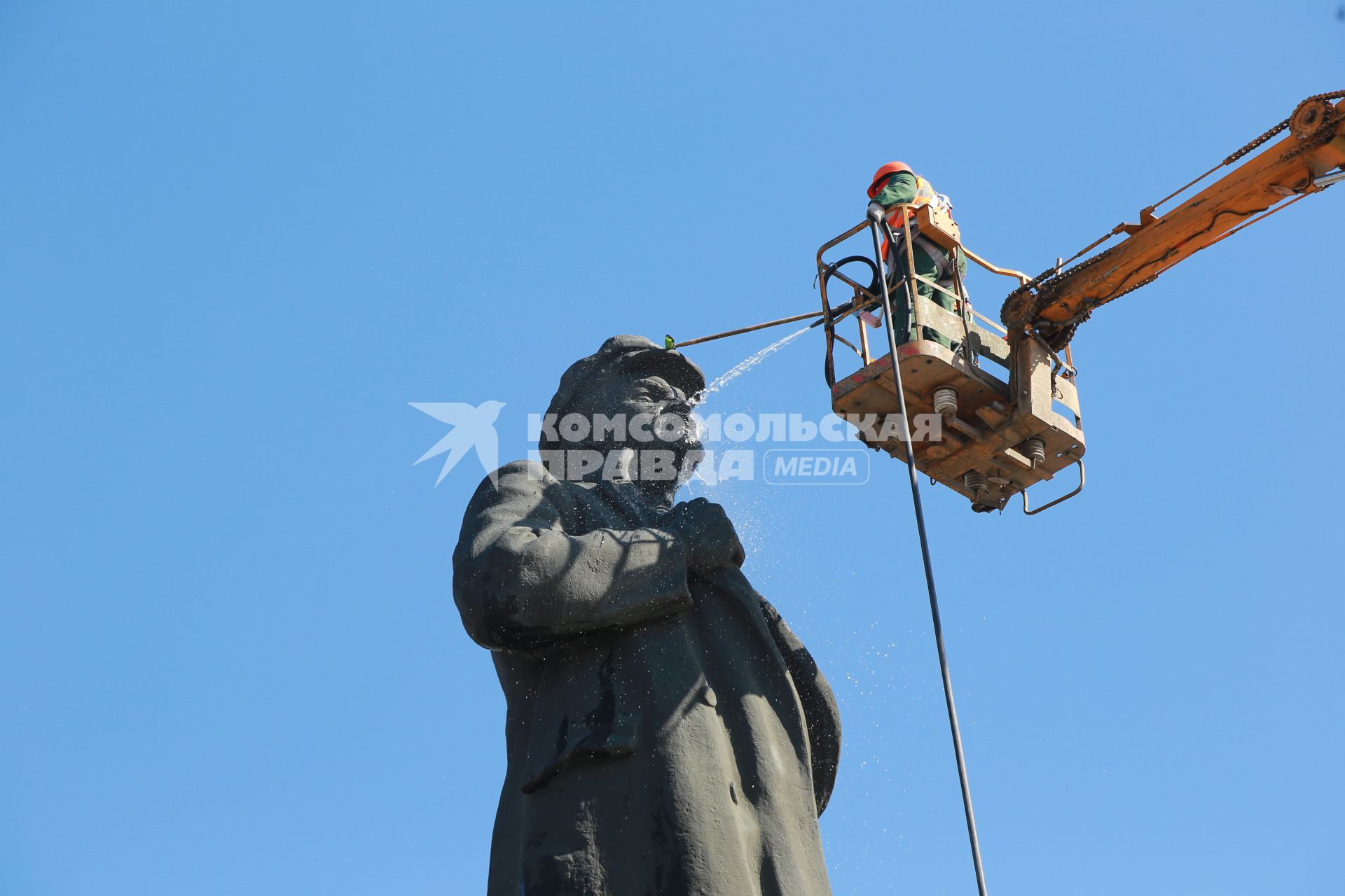 Красноярск.   Сотрудник коммунальных служб моют памятник  В.И. Ленину на одной из улиц города.