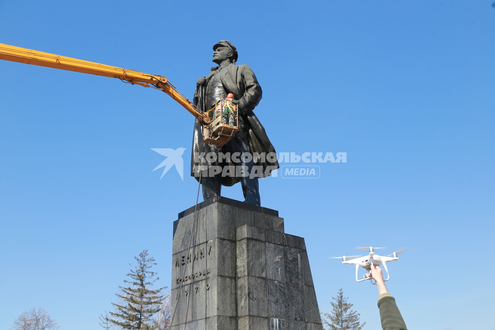 Красноярск.   Сотрудники коммунальных служб моют памятник  В.И. Ленину на одной из улиц города.