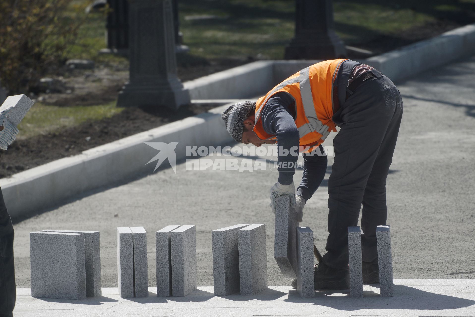 Екатеринбург. Рабочий-мигрант перекладывает плитку на набережной реки Исеть