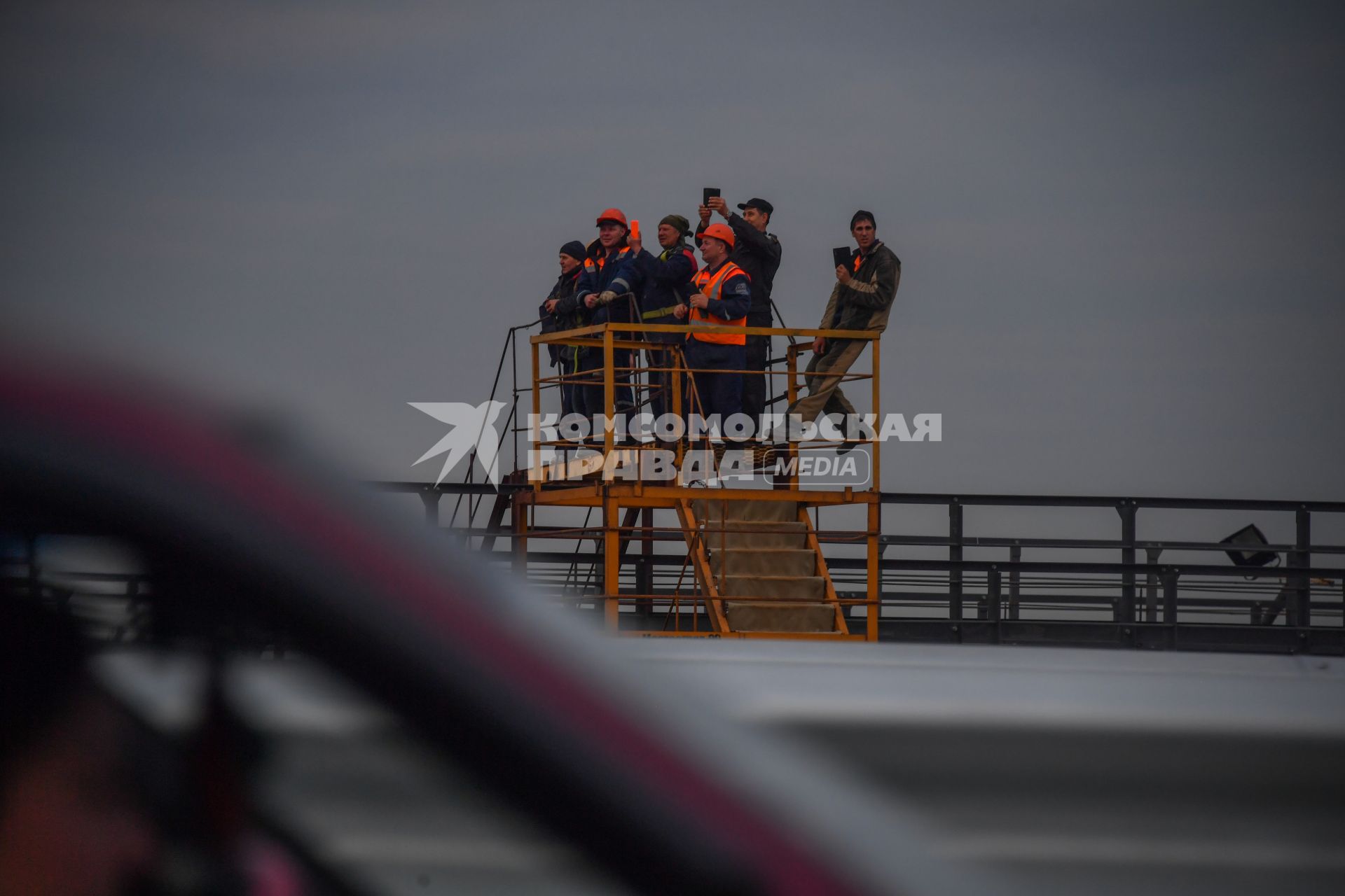 Тамань. Дорожные рабочие фотографируют  открытие  движения по автодорожной части Крымского моста через Керченский пролив.