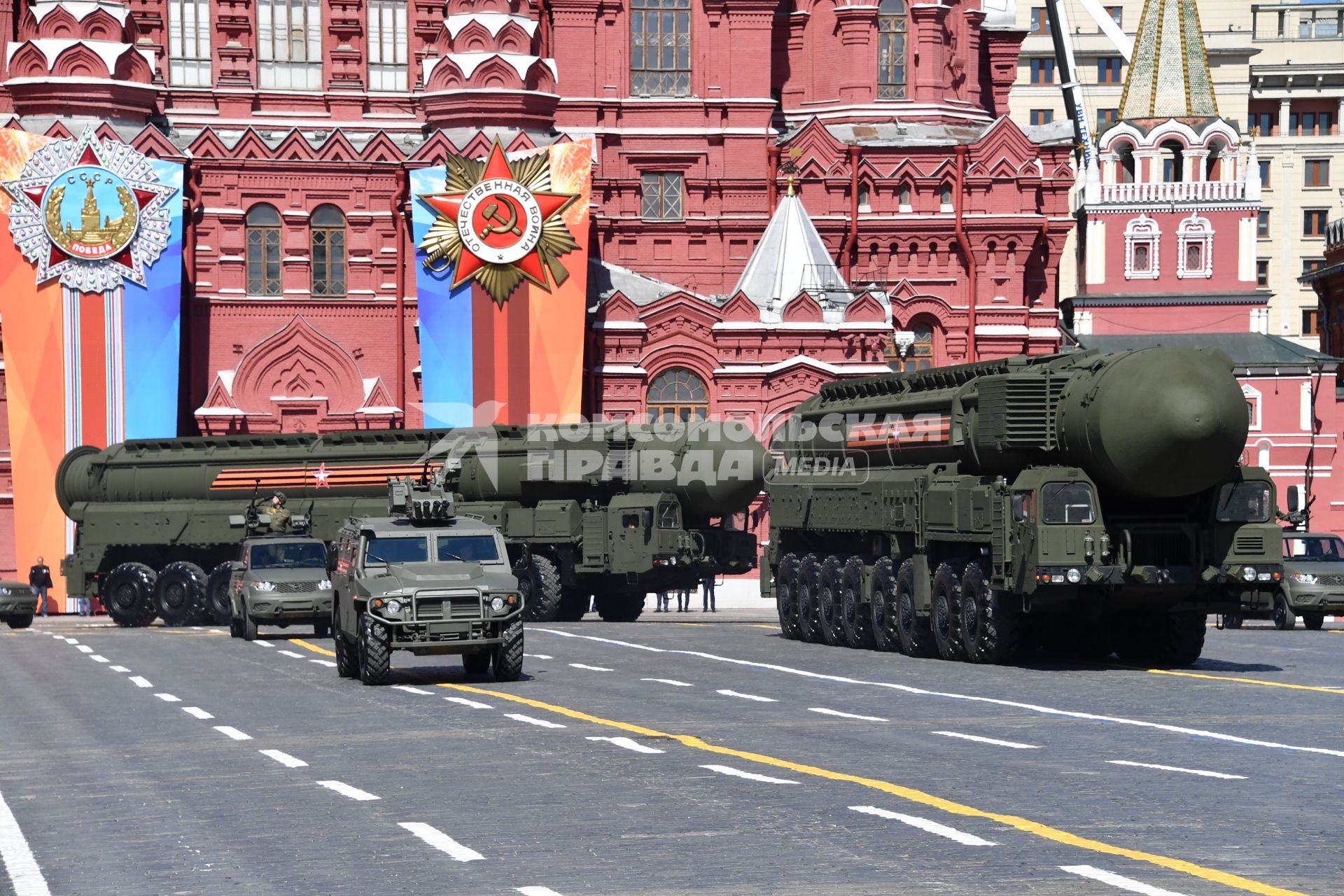 Москва. Автомобиль УАЗ `Пикап`(слева на втором плане),  бронеавтомобиль `Тигр - М` и транспортно-пусковой контейнер комплекса РС-24 `Ярс` (справа) на Красной площади во время военного парада, посвященного 73-й годовщине Победы в Великой Отечественной войне.