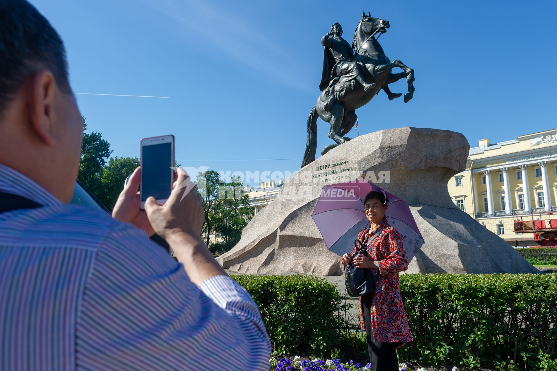 Санкт-Петербург.  Женщина фотографируется на фоне памятника Петру I `Медный всадник` на Сенатской площади.