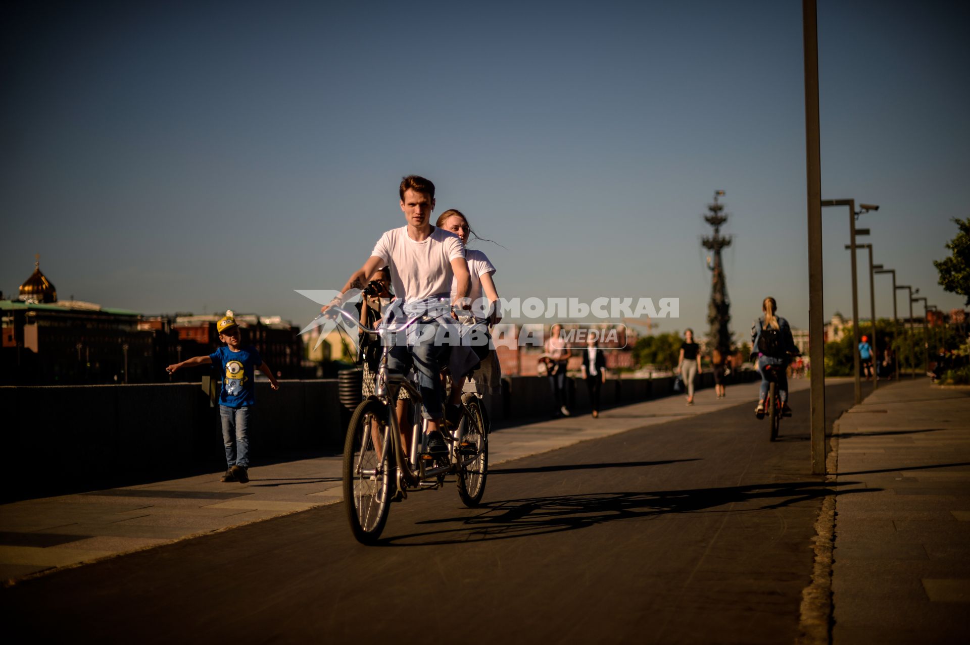 Москва.  Молодые люди на велосипедах на Крымской набережной.