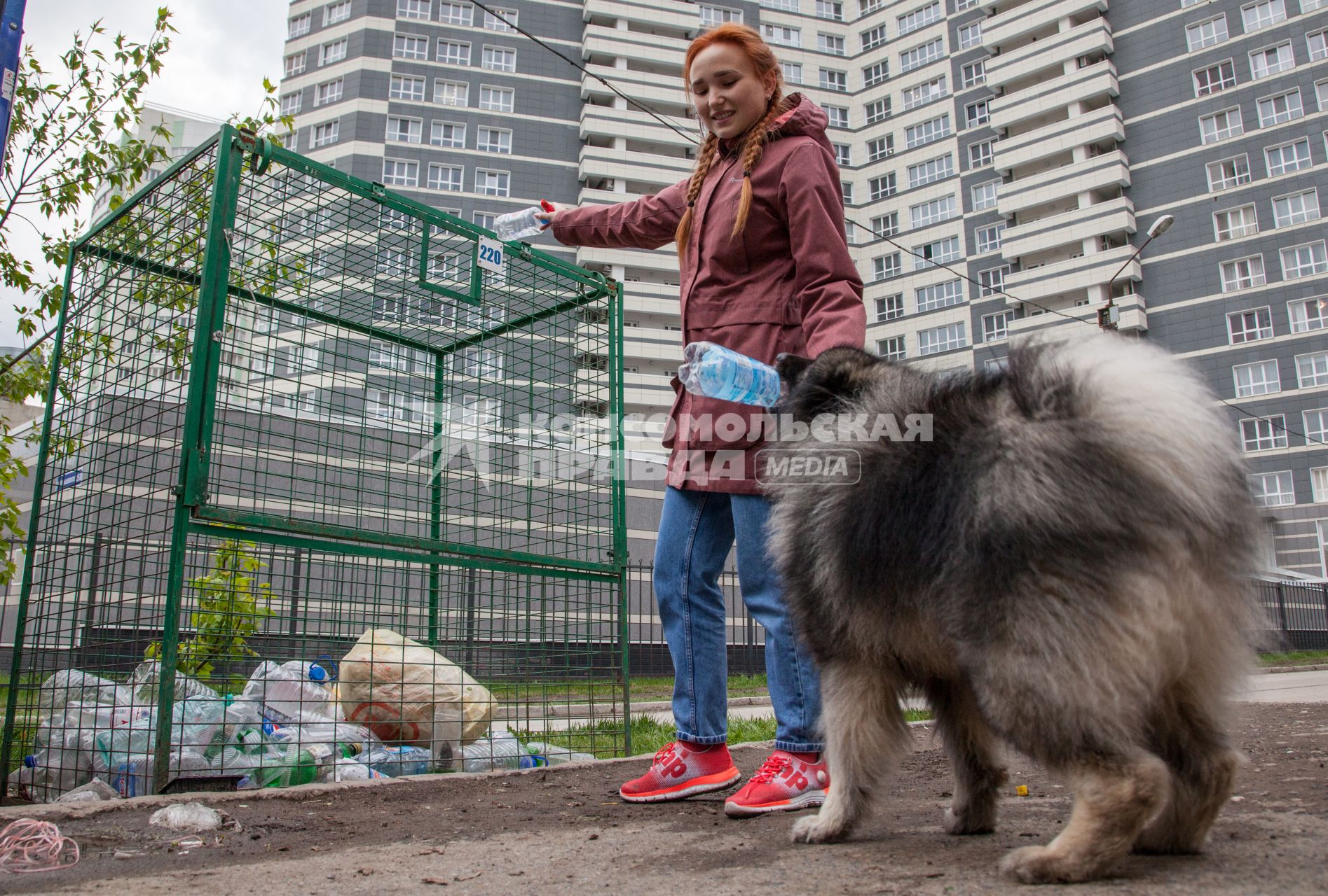 Пермь. Девушка выбрасывает мусор в контейнер для раздельного сбора пластиковых бутылок.