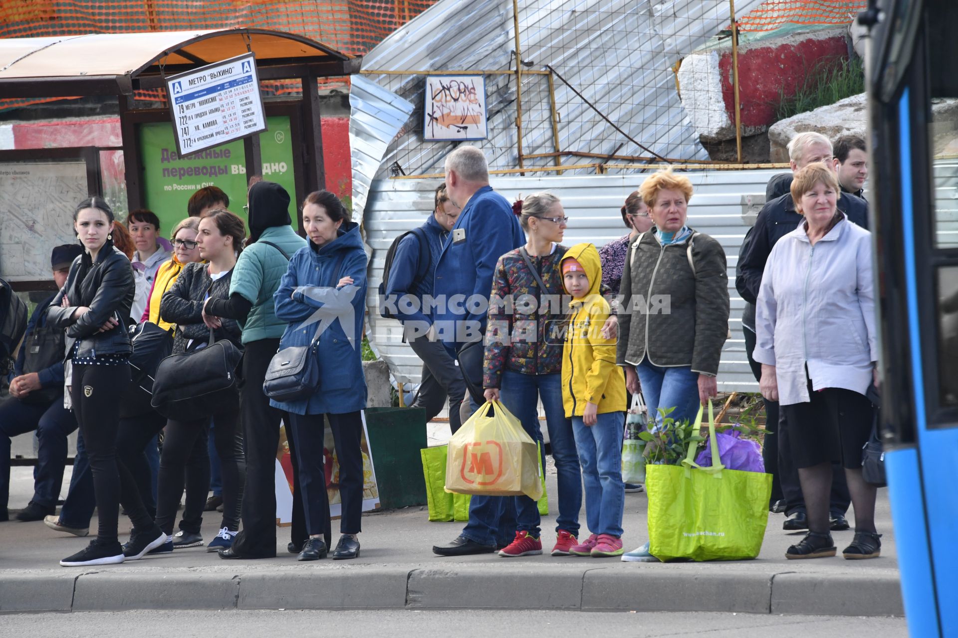 Москва.   Пассажиры на автобусной остановке.