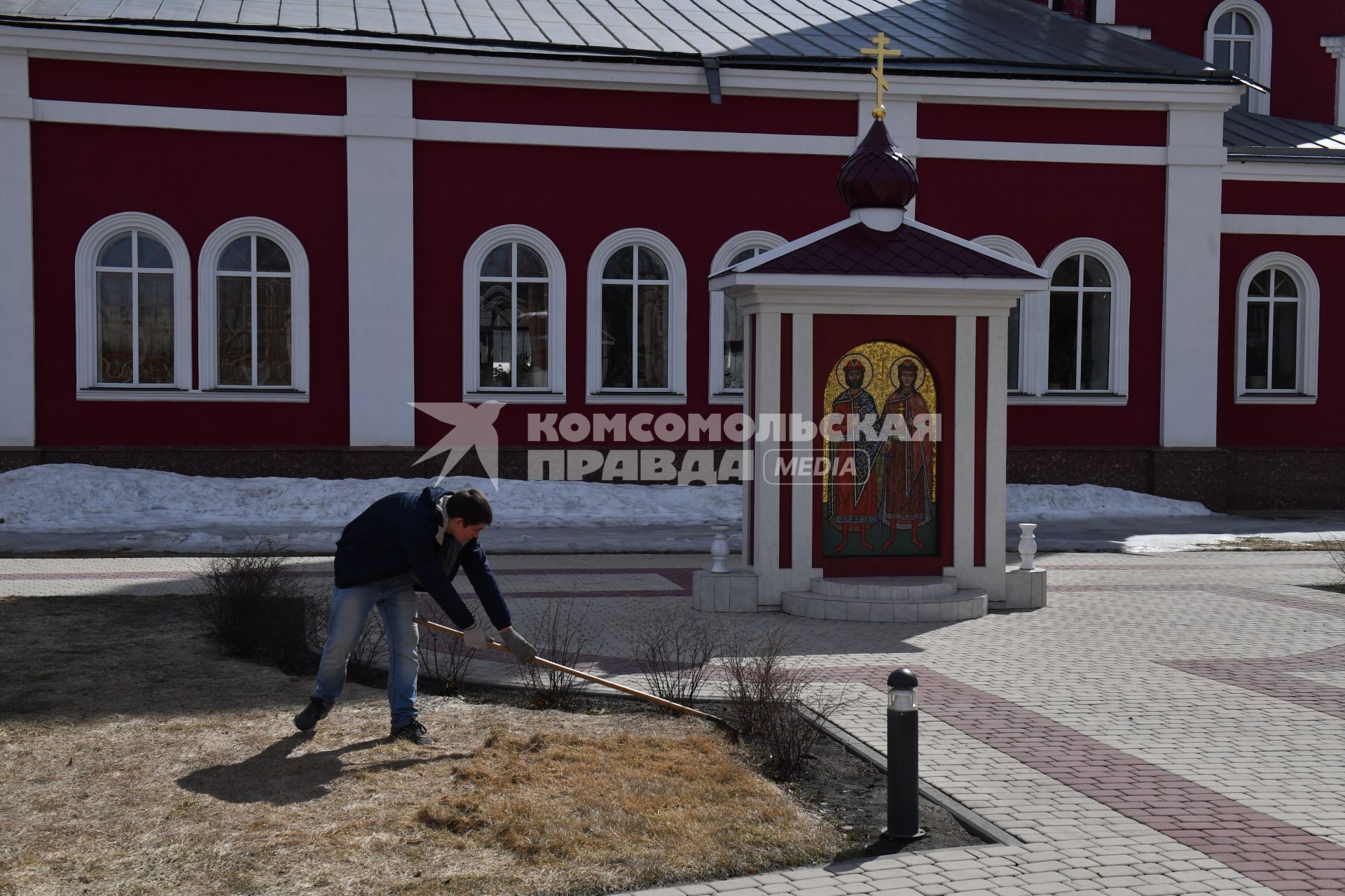 Борисоглебск. Мужчина  убирает территорию храма.