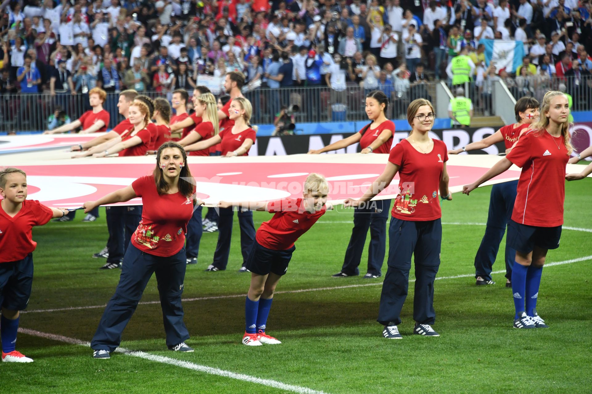 Москва. Волонтеры держат баннер с эмблемой чемпионата перед началом матча 1/2 финала ЧМ-2018 по футболу между сборными  Хорватии и Англии.