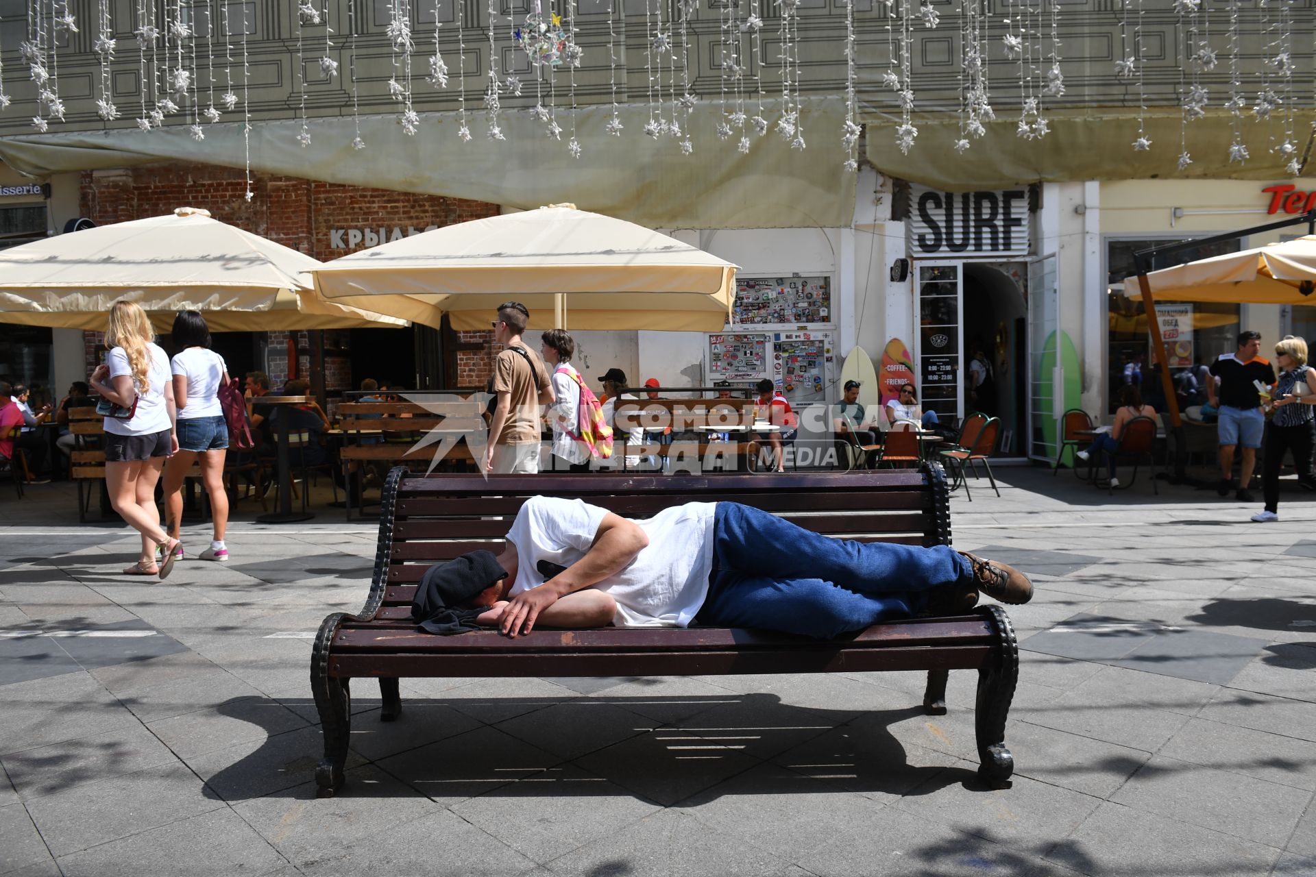 Москва. Мужчина спит на лавочке на Никольской улице.