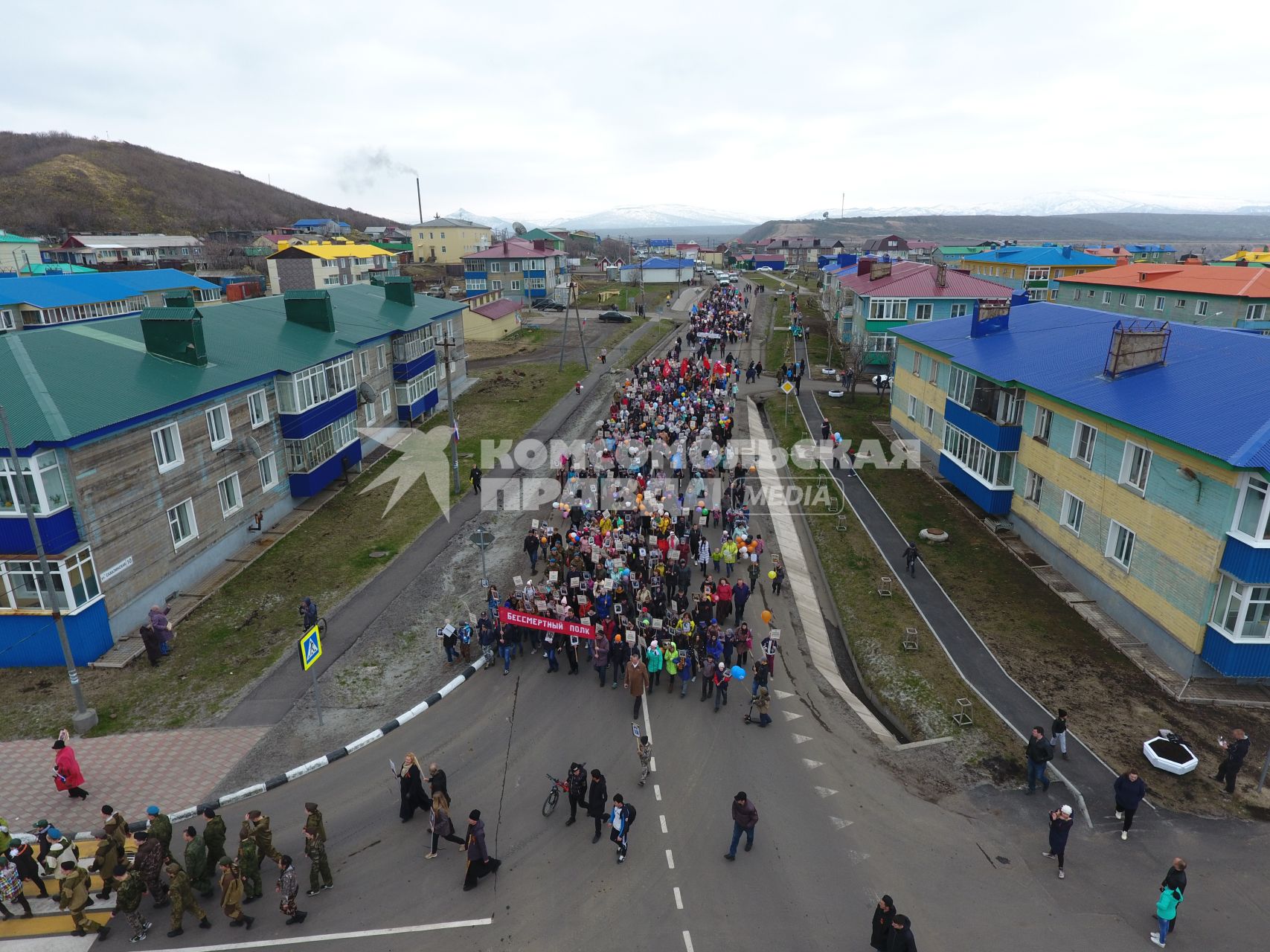 Остров Итуруп, Курильск. Колонна демонстрантов на центральной улице города в день празднования 73-й головщины Победы в Великой Отечественной войне.