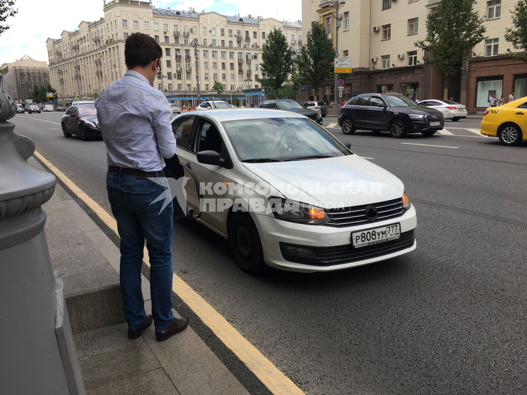 Москва.  Мужчина останавливает частный автомобиль на Тверской улице.