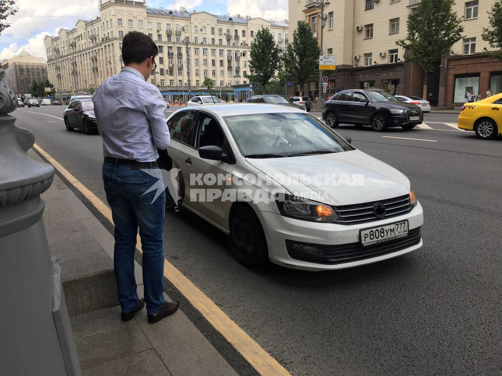 Москва.  Мужчина останавливает частный автомобиль на Тверской улице.