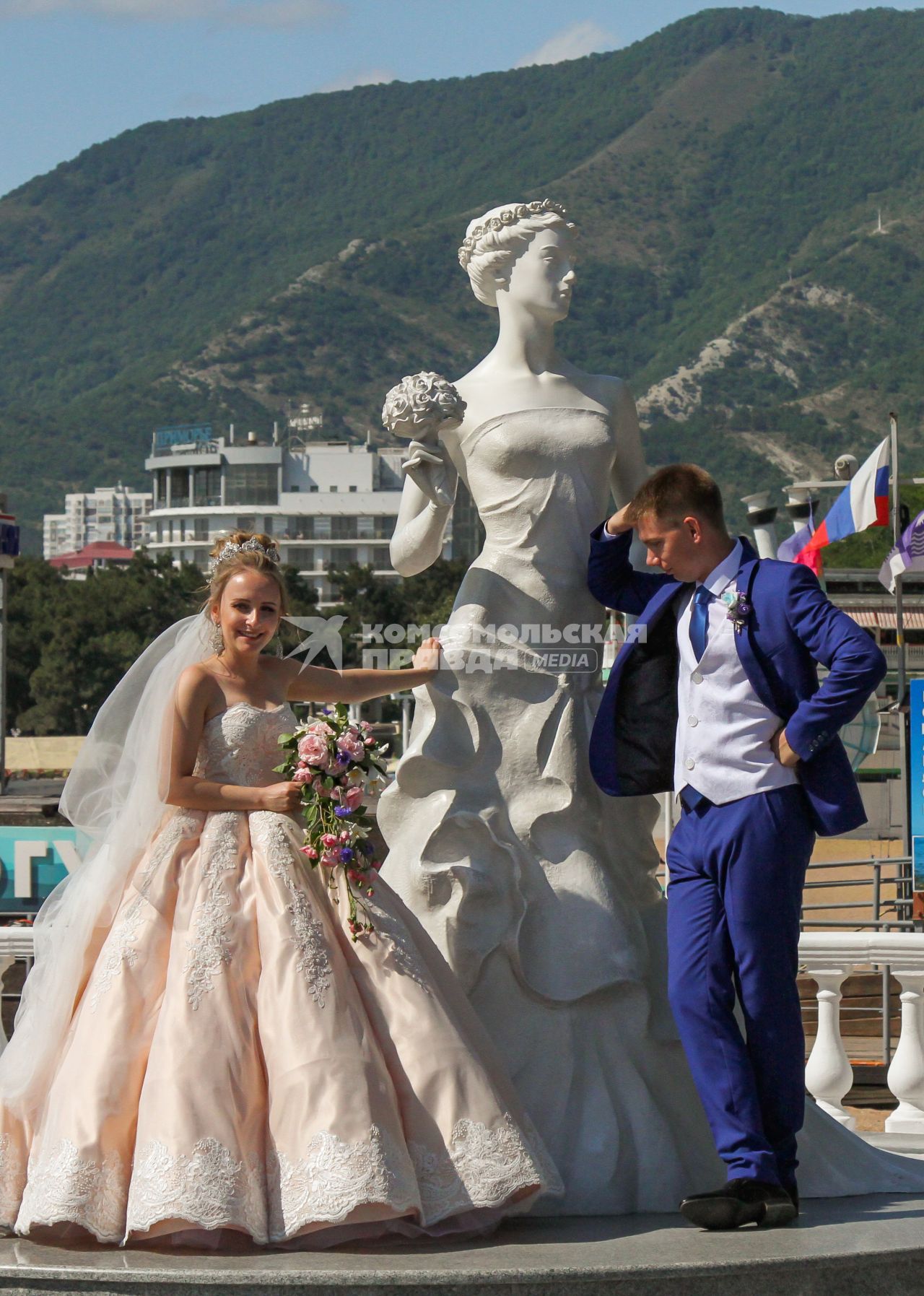 Геленджик. Молодожены фотографируются у памятника `Белая невеста` на набережной города.