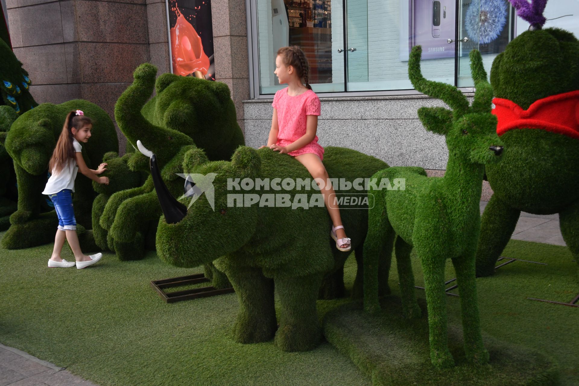 Москва. Дети фотографируются на зеленых фигурах.