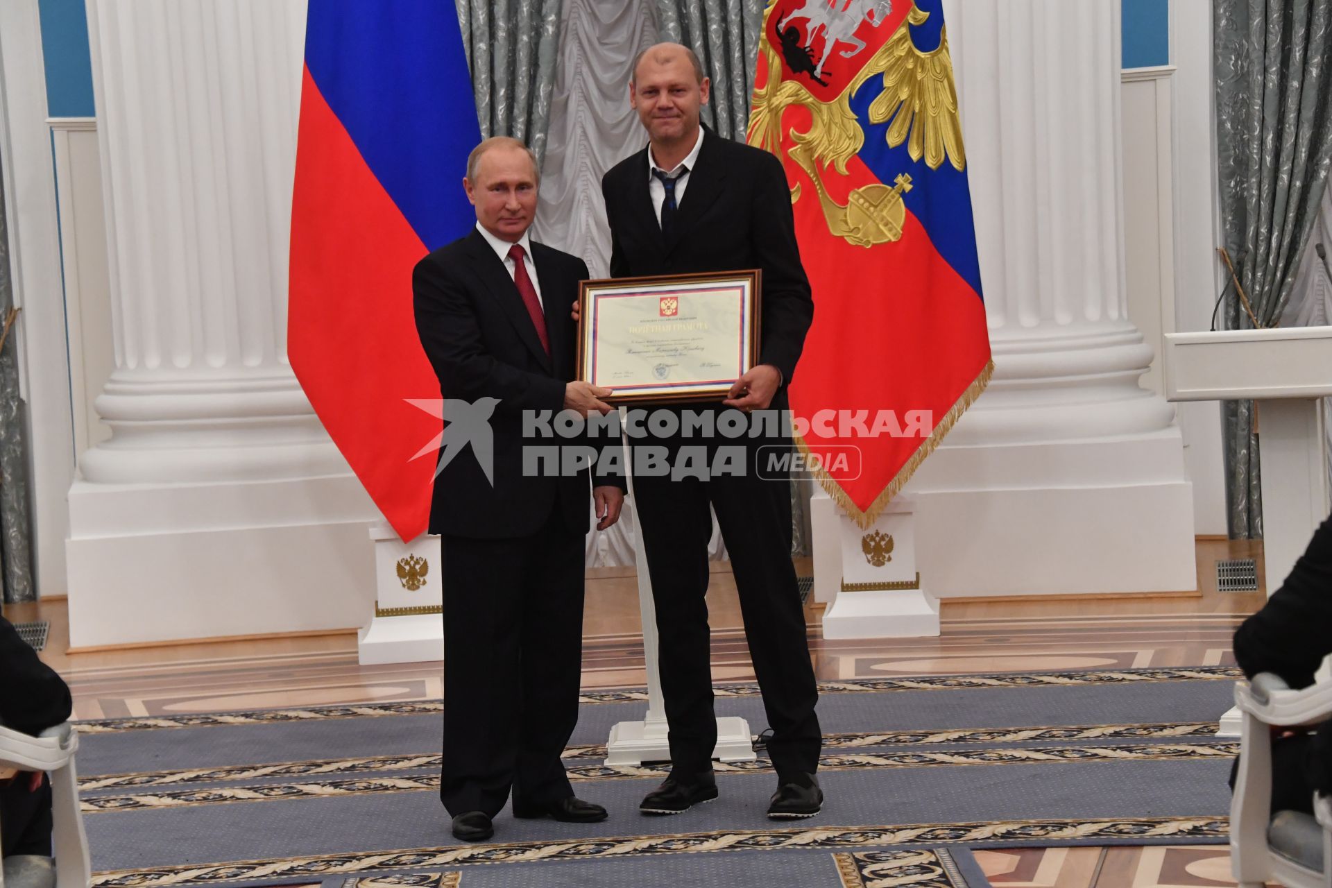 Москва. Президент РФ Владимир Путин и тренер сборной России по футболу Мирослав Ромащенко (справа) на церемонии вручения государственных наград и почетных грамот игрокам и тренерам сборной России по футболу - участникам чемпионата мира по футболу - 2018 в Екатерининском зале Кремля.