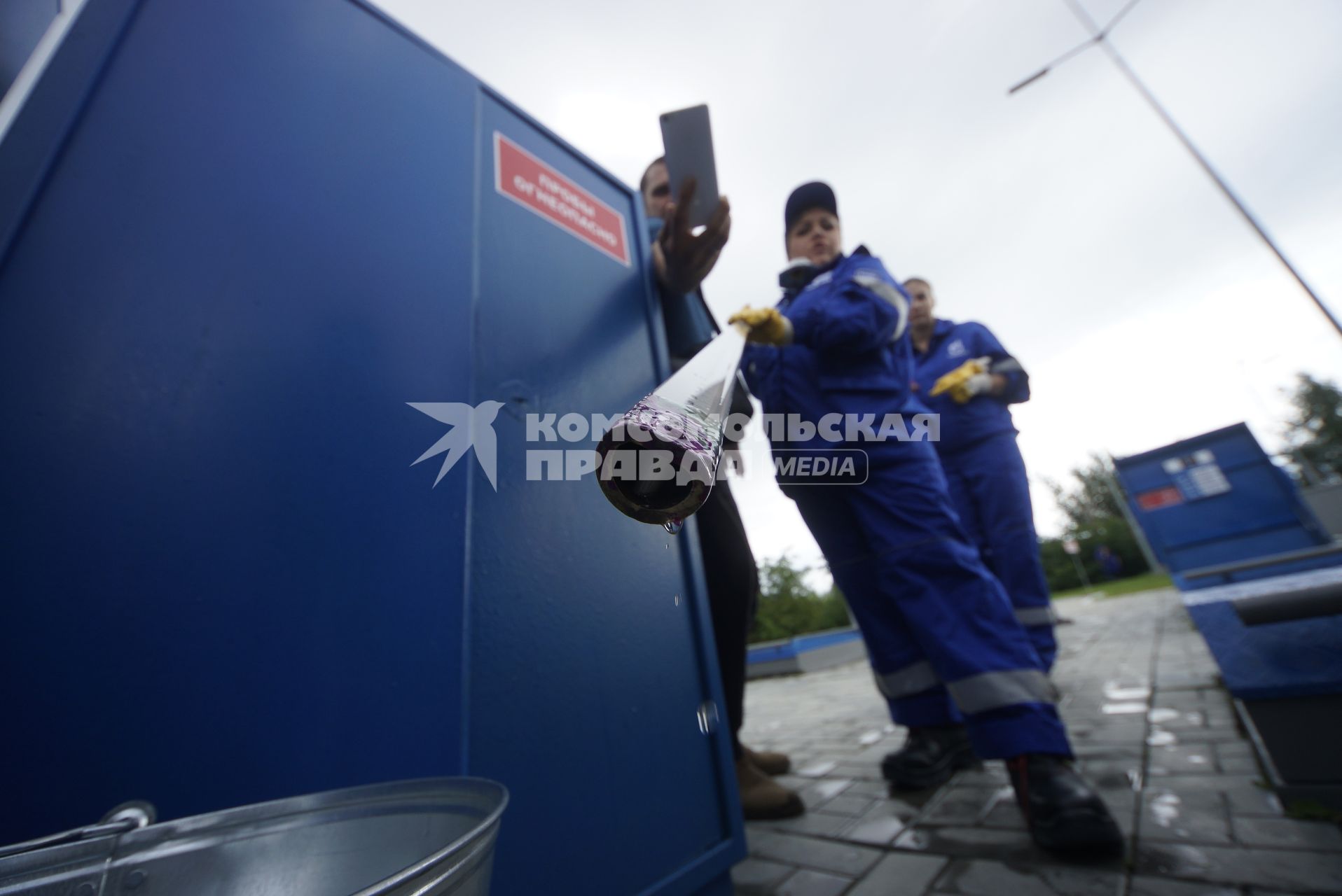 Екатеринбург. Оператор АЗС проверяет металлическим щупом наличие воды в топливном резервуаре на автозаправочной станции \'Газпромнефть\'