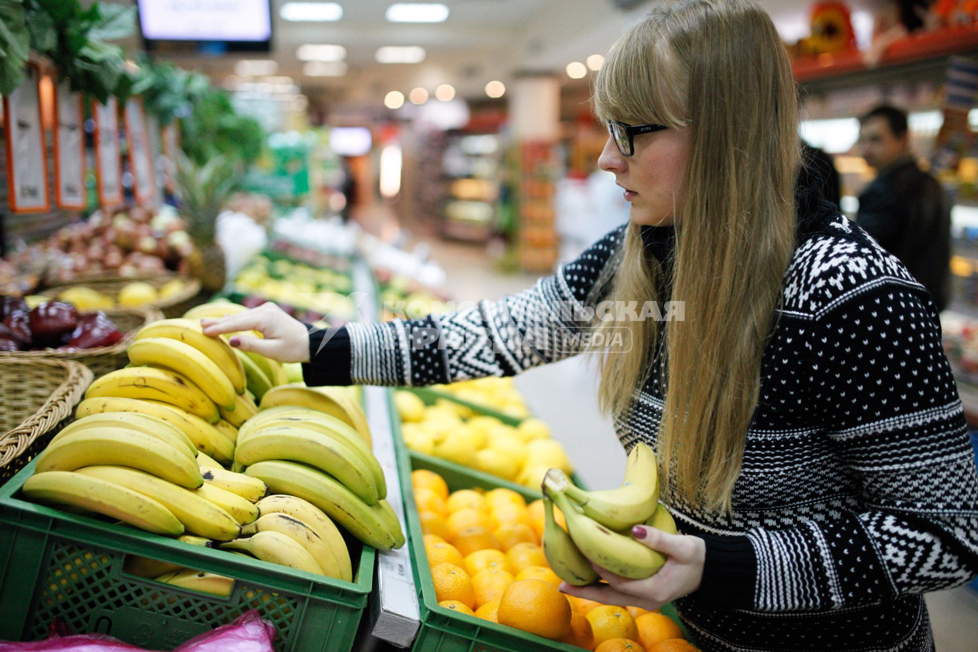 Ставрополь.  Девушка выбирает бананы в магазине.