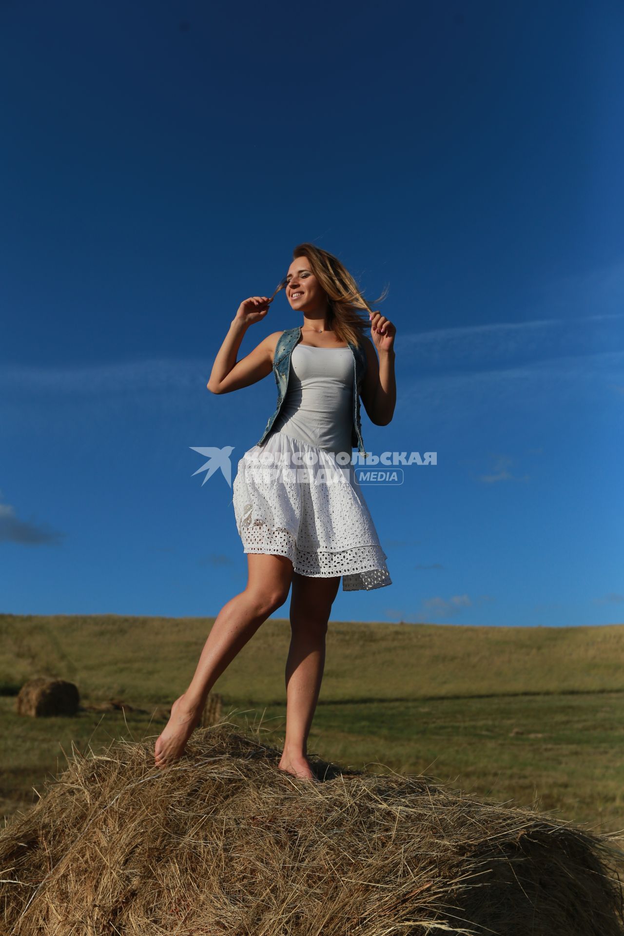 Красноярск.  Девушка стоит на стоге сена.