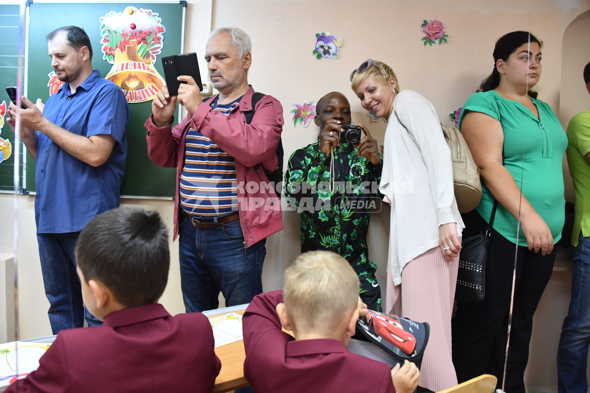 Москва. Родители фотографируют детей  после торжественной линейки, посвященной Дню знаний.