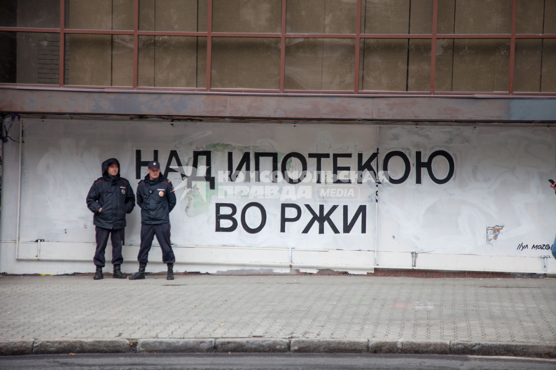 Пермь. Полицейские стоят возле стены с надписью `Над ипотекою во ржи`.