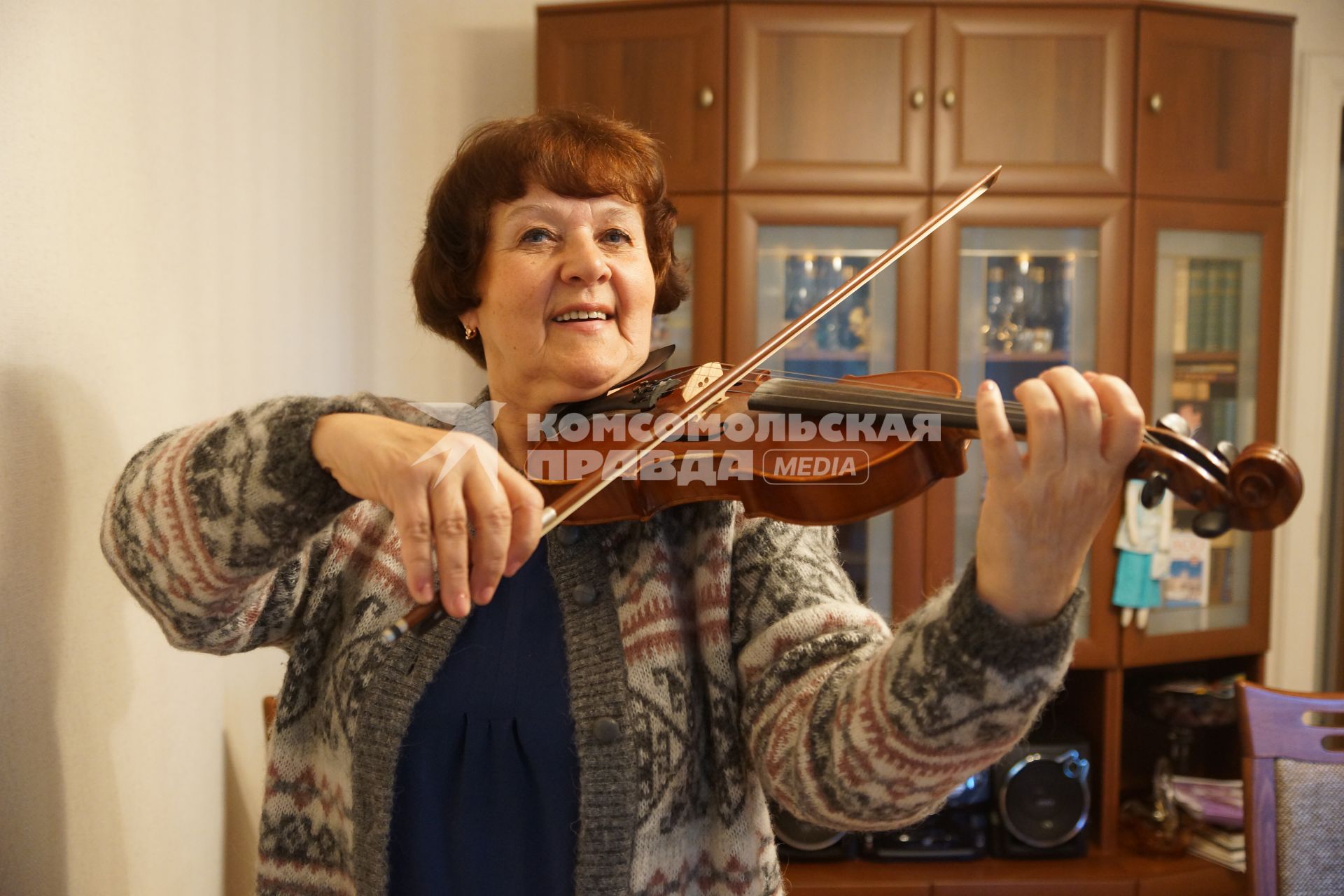 Самара. Женщина пенсионного возраста играет на скрипке.