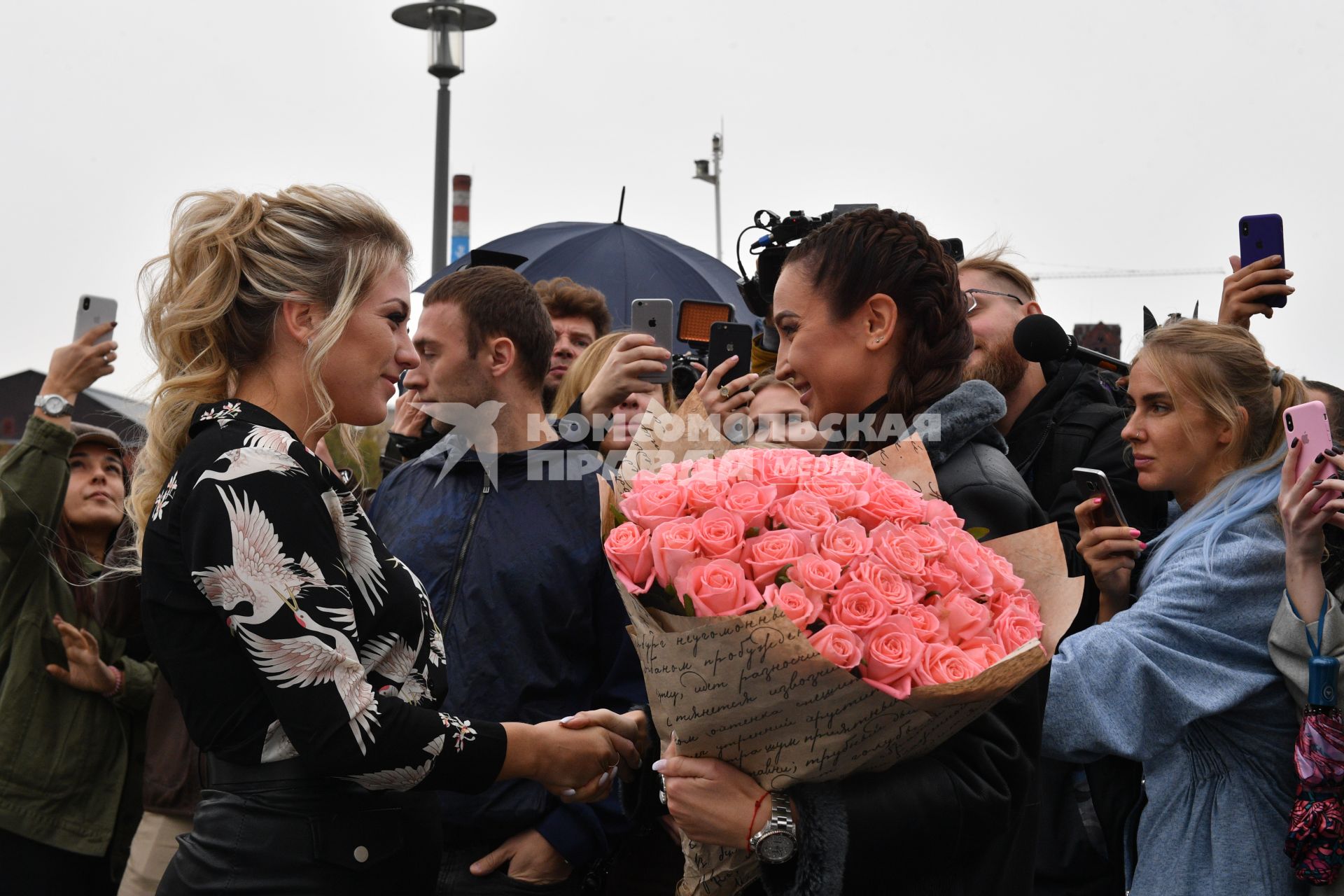 Москва. Телеведущая Ольга Бузова (справа) вручила ключи победительнице `гива` - девушке-блогеру.