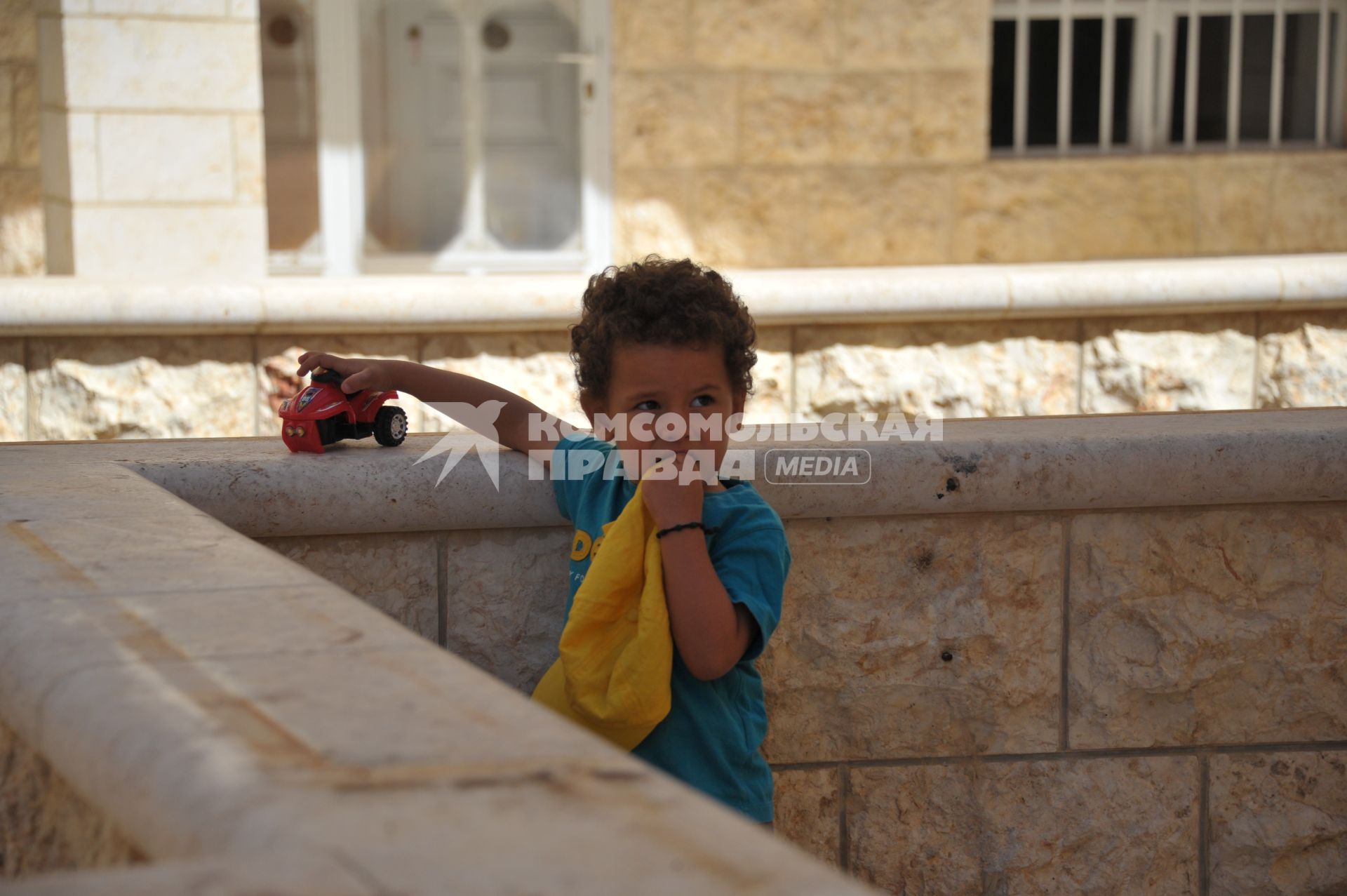 Сирия, Маалюл. Мальчик играет у стен восстановленного после захвата и разрушения боевиками храма в Маалюла.