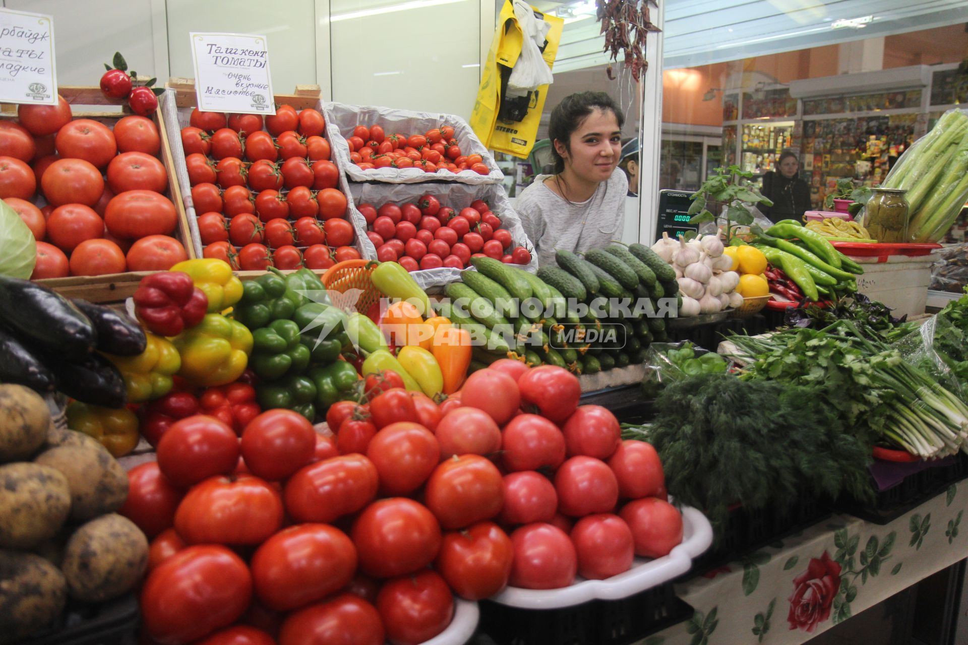 Иркутск.  Девушка торгует овощами на рынке.