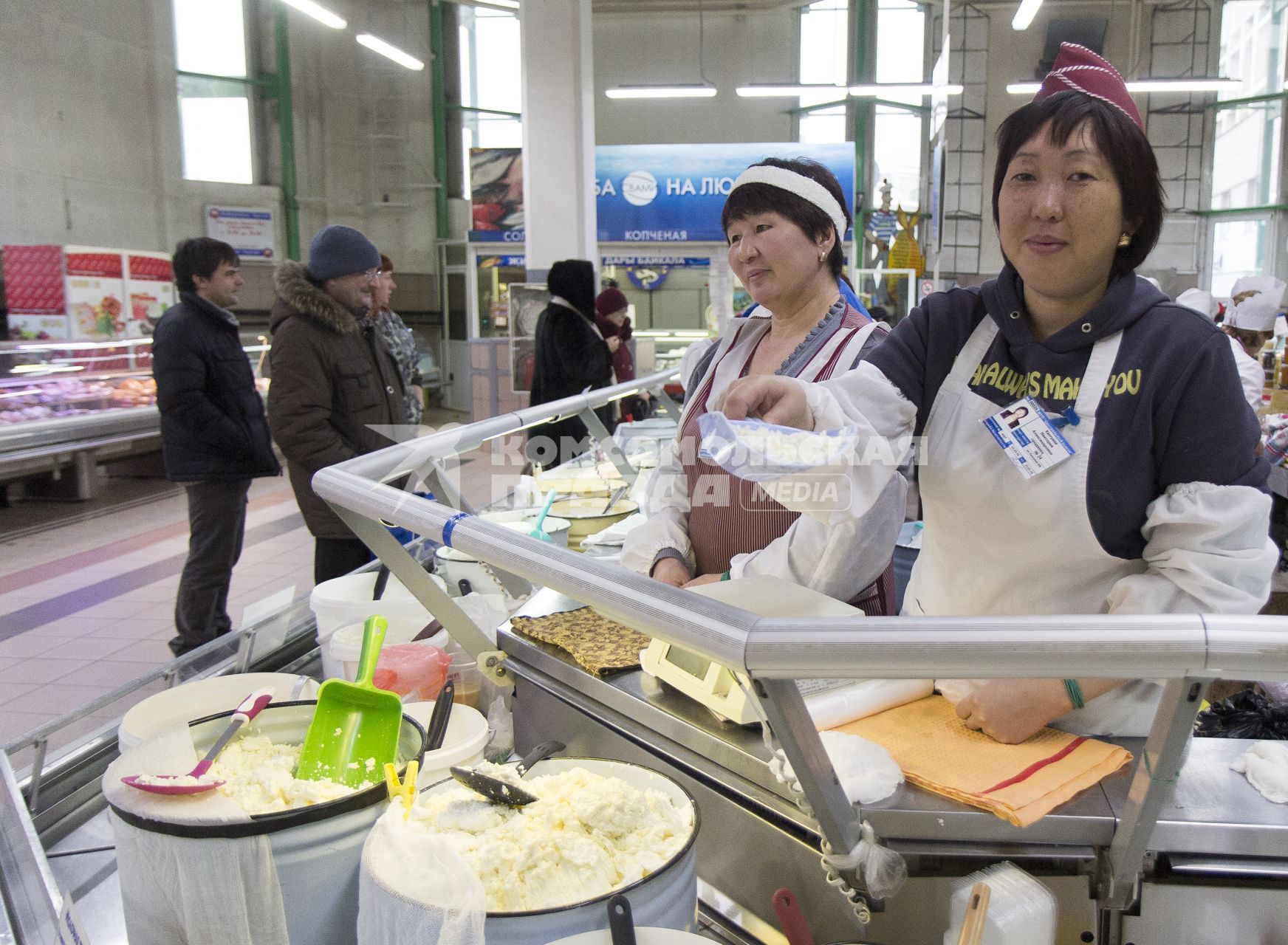 Иркутск.   Женщины торгуют молочной продукцией на рынке.