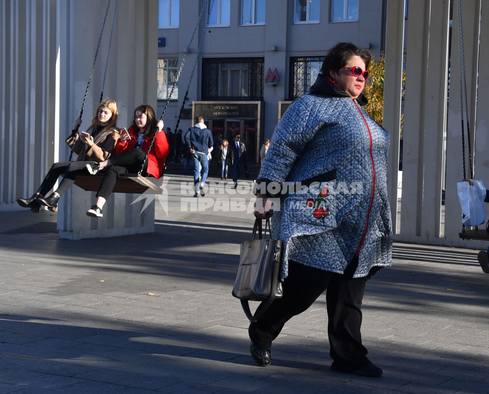 Москва. Девушки качаются на качелях.