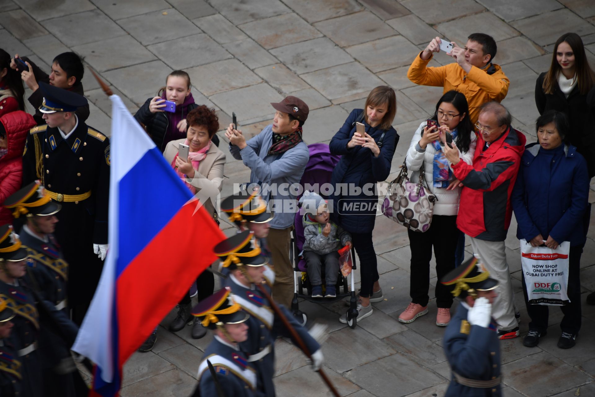 Москва.   Китайские туристы фотографируют церемонию  развода пеших и конных караулов Президентского полка в Кремле на Соборной площади.