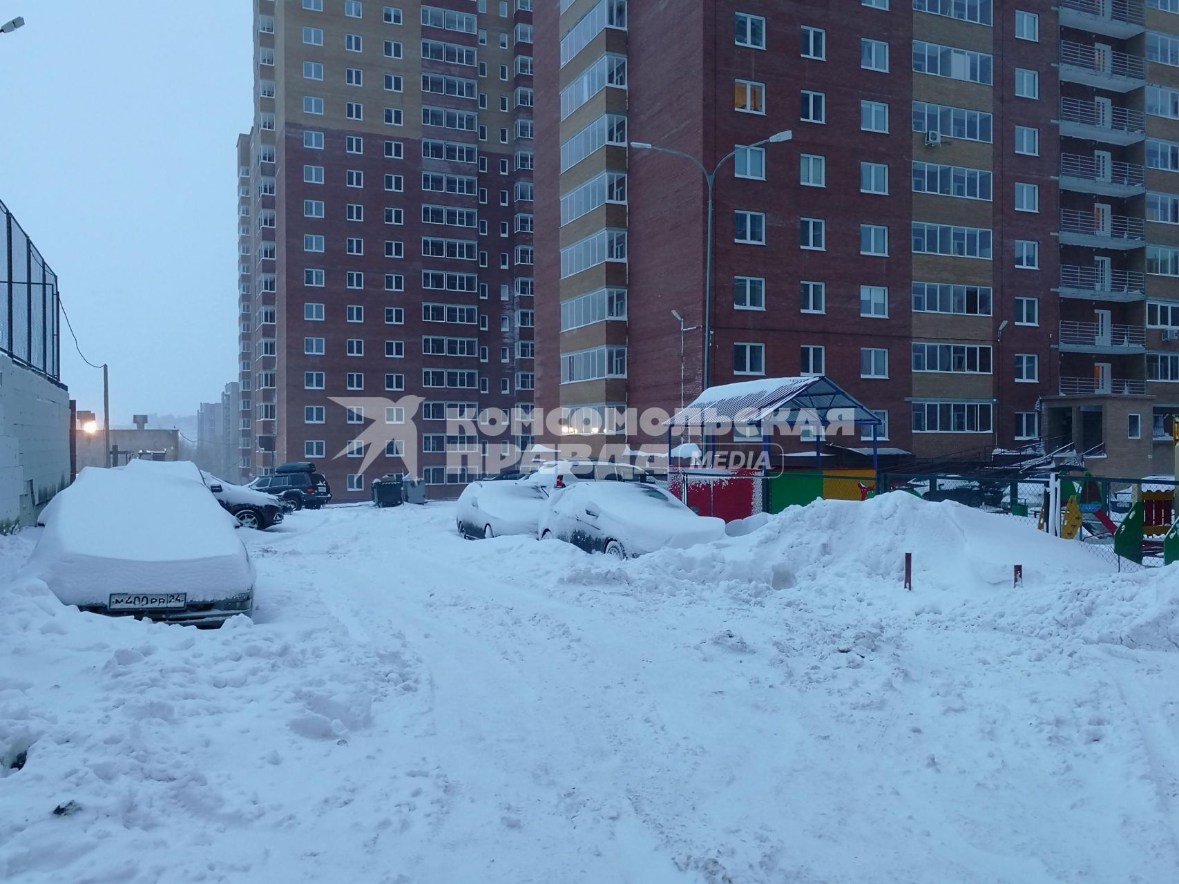 Красноярск.  Занесенные снегом машины на стоянке во дворе дома.