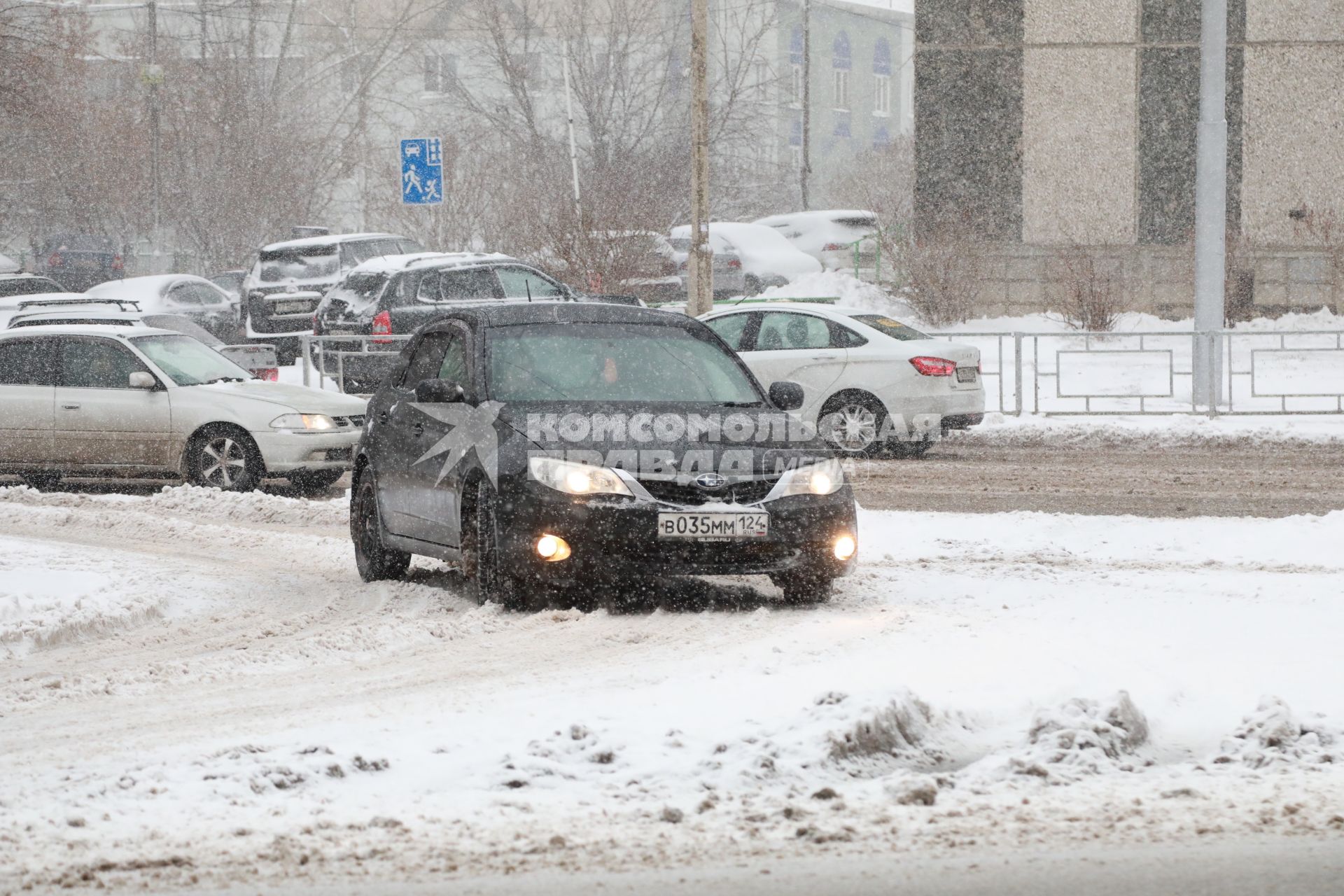 Красноярск. Занесенной снегом машины на улице города.