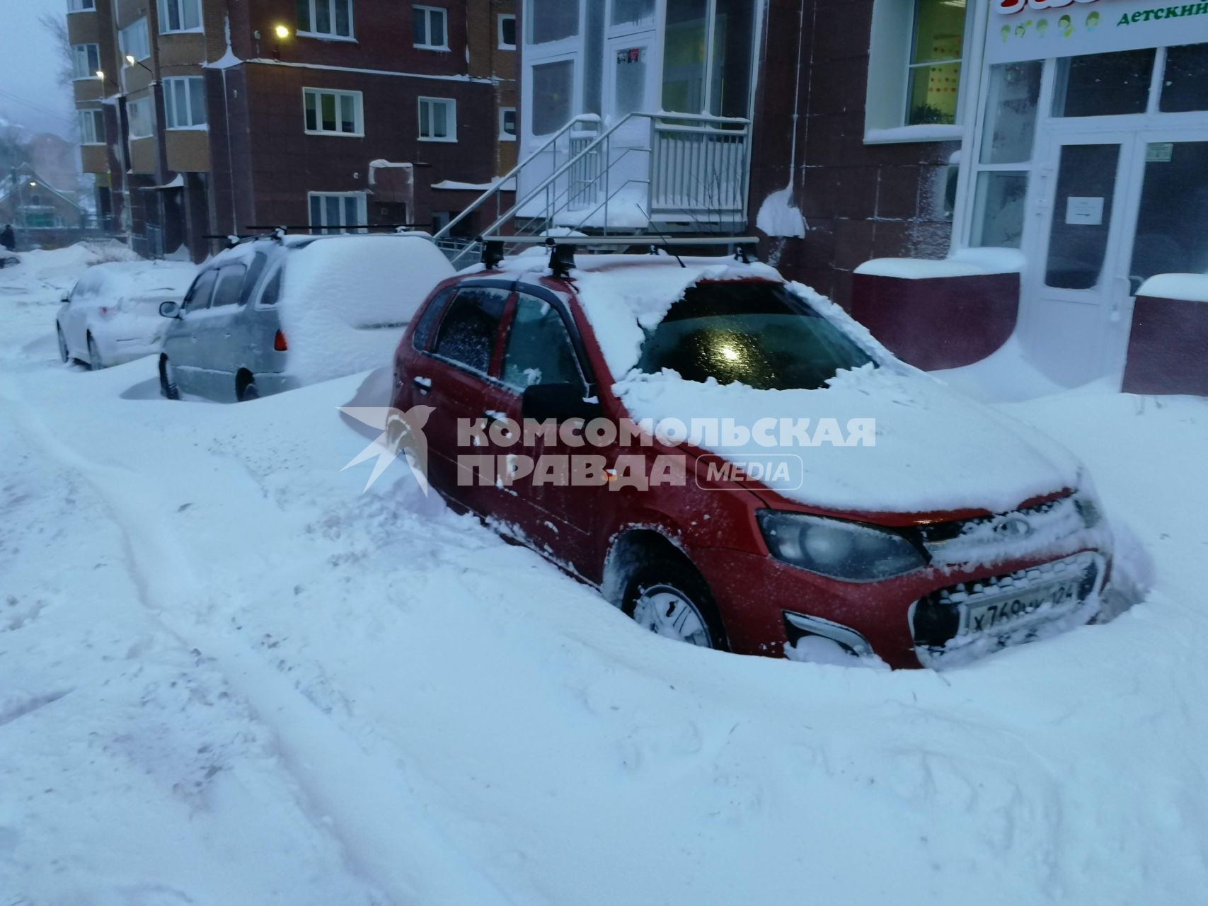 Красноярск.  Занесенные снегом машины на стоянке во дворе дома.