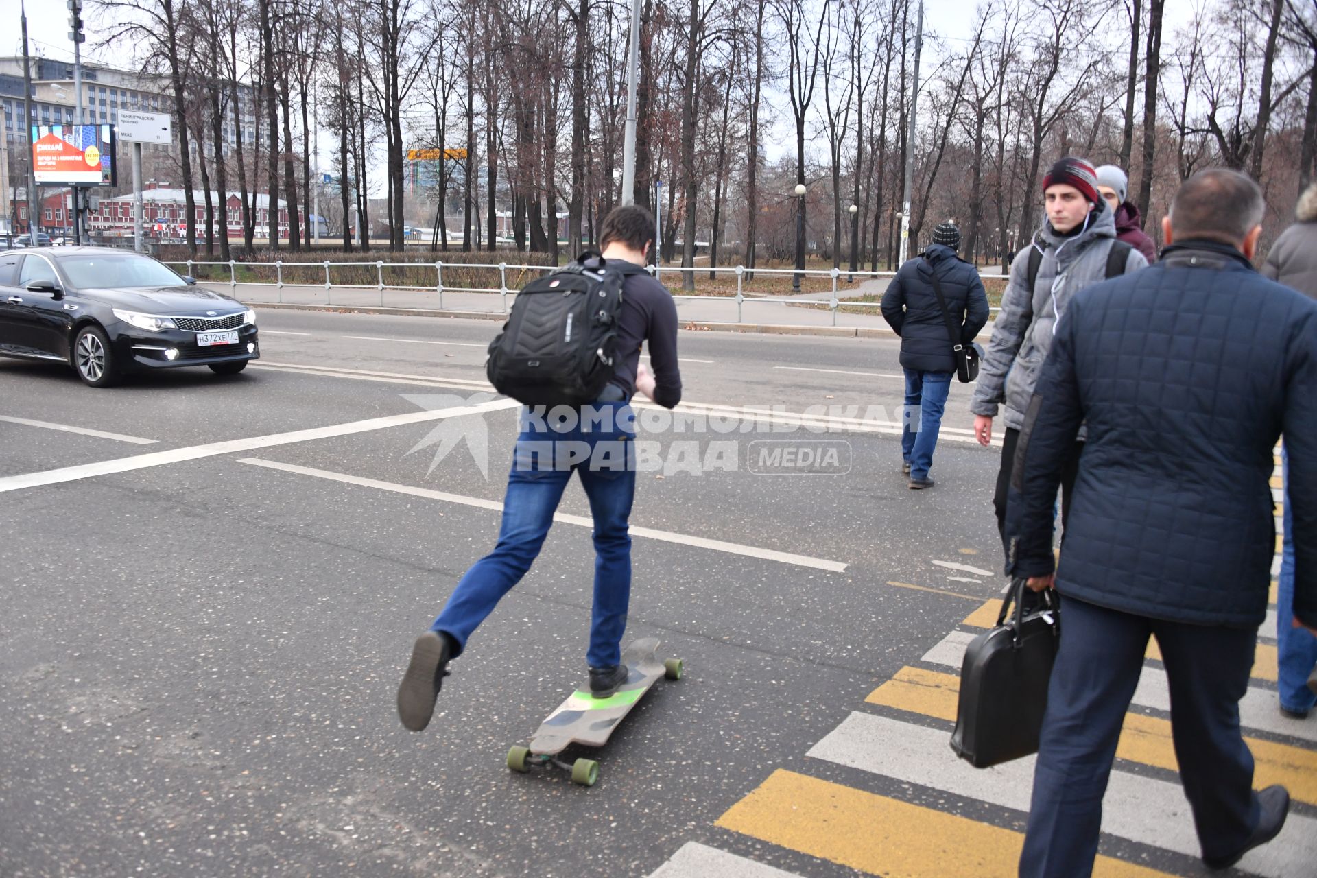 Москва. Мужчина со скейтбордом на пешеходном переходе.