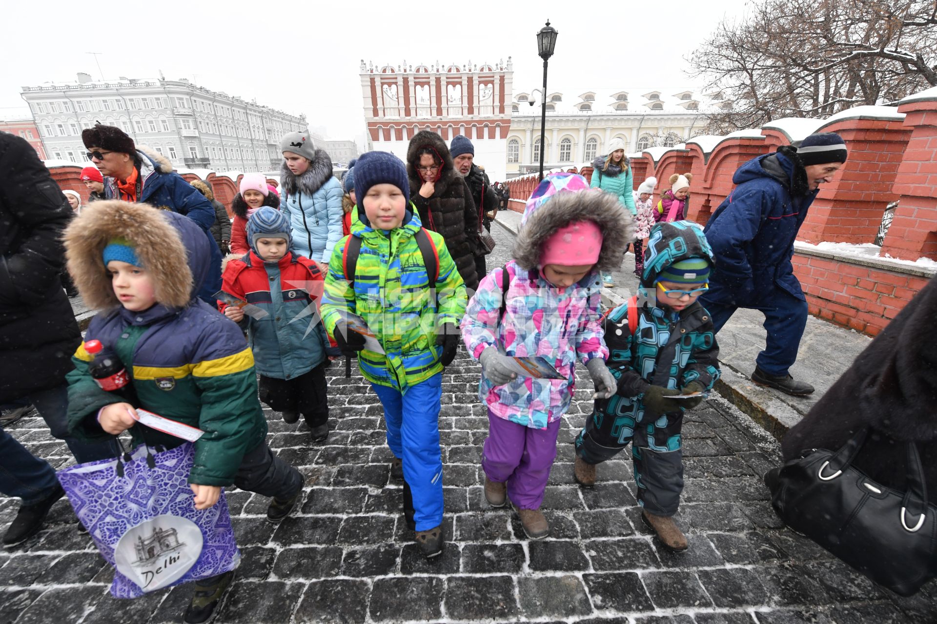 Москва.  Дети идут в Кремль по Троицкому мосту.