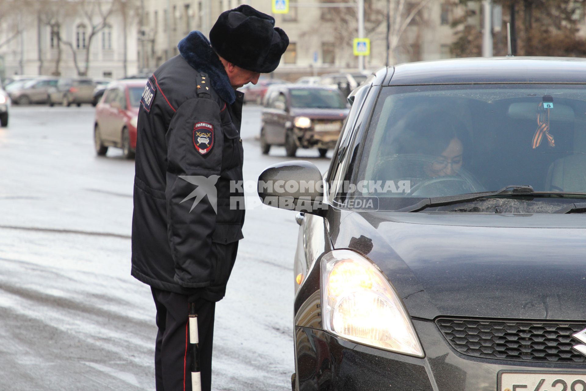Иркутск.  Сотрудник  полиции проверяет документы у водителя.