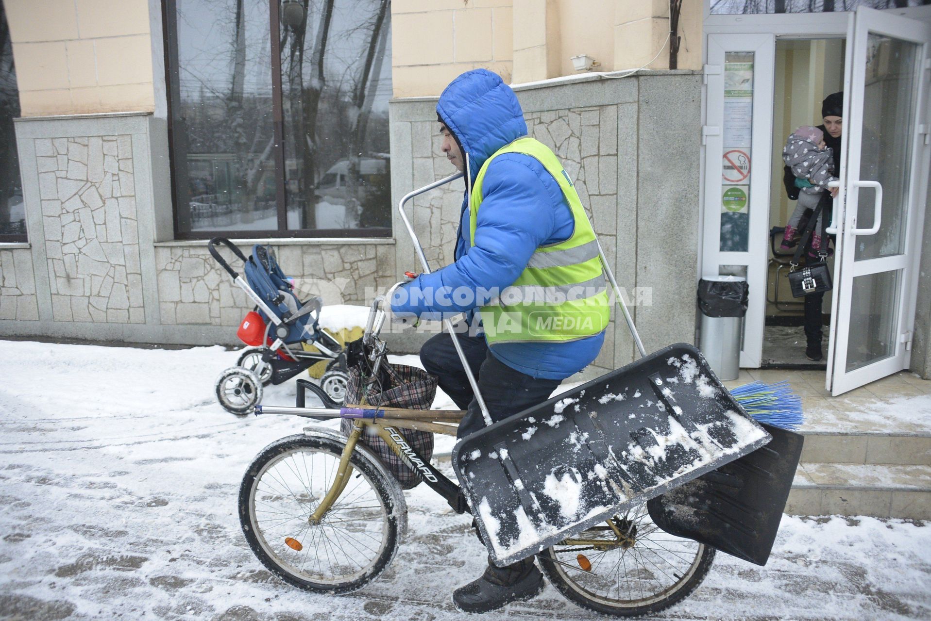 Тула. Дворник на велосипеде на одной из улиц города.